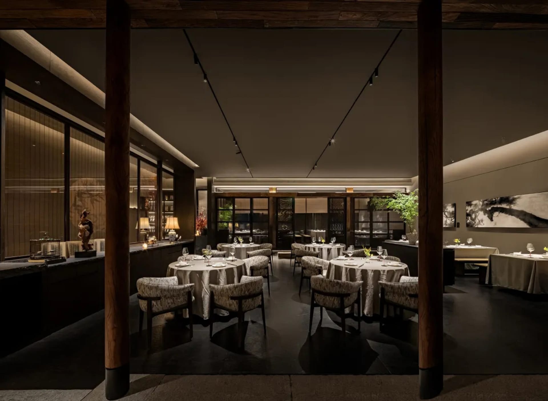 Elegant restaurant interior with multiple tables, chairs, and decorative items, creating a sophisticated atmosphere for upscale dining