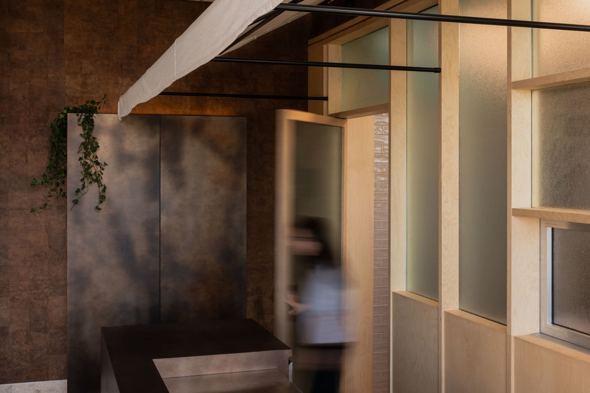 A woman walks down a professional office hallway with two doors, one on either side