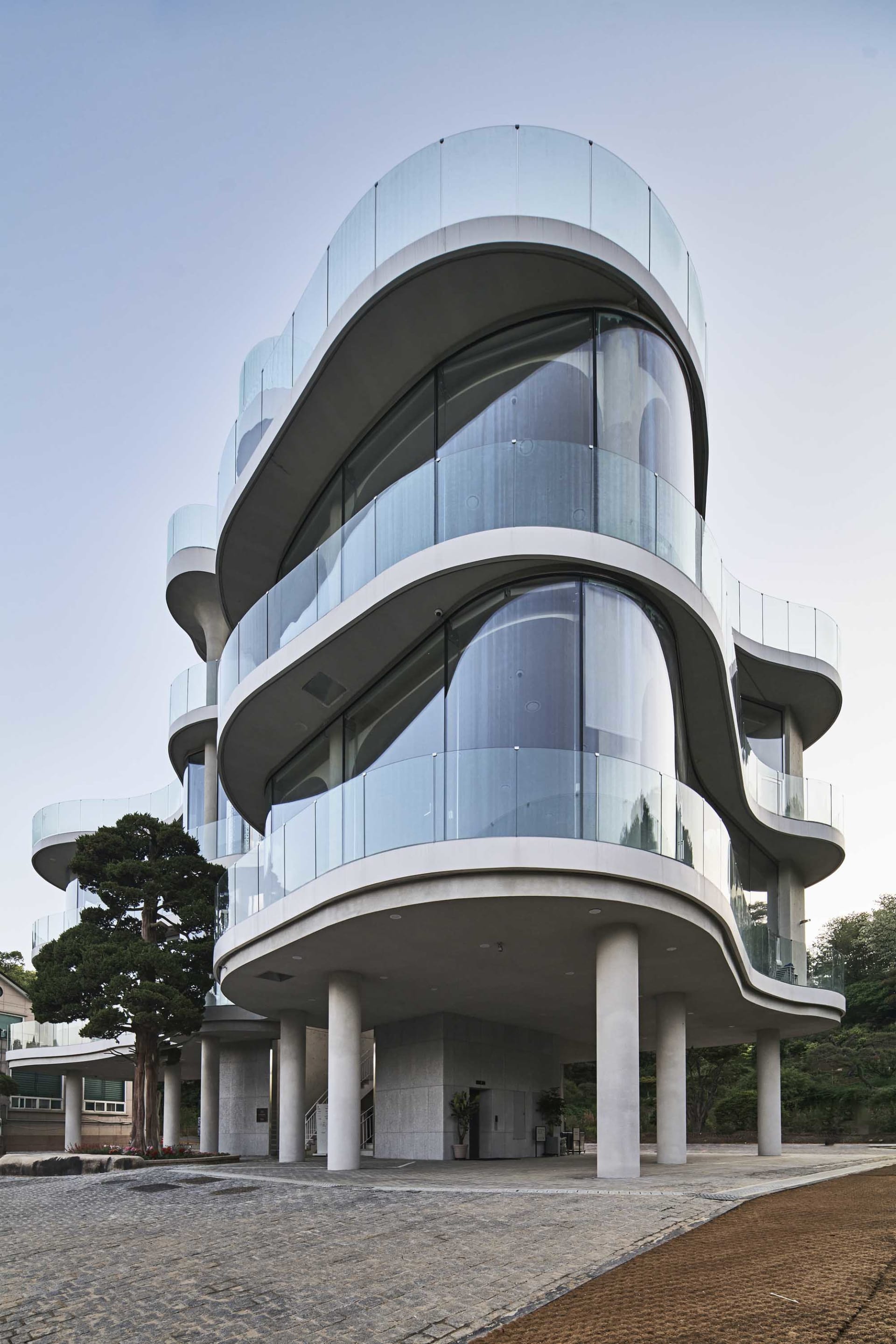 A modern high-rise building with a glass facade, multiple levels, and a sophisticated urban atmosphere