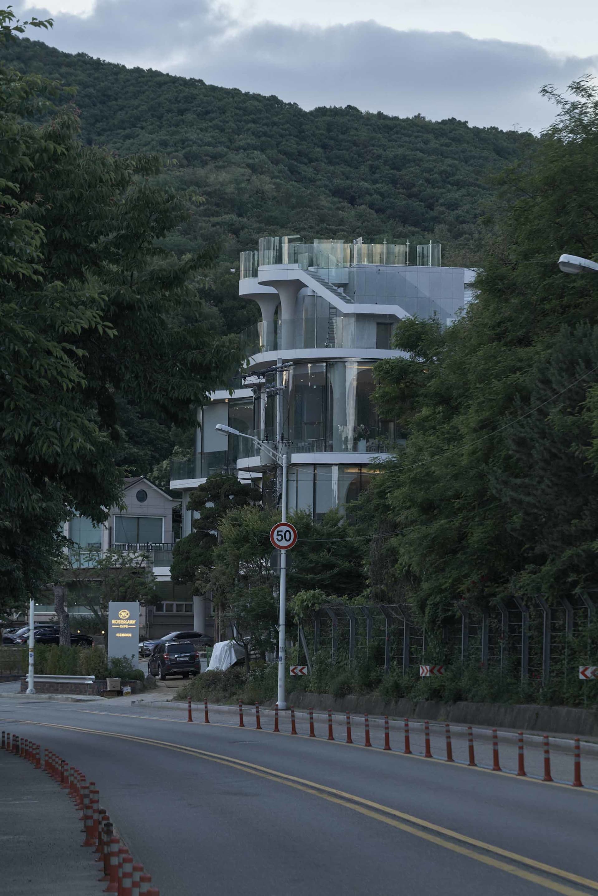 現代商業建築，擁有大型玻璃結構，搭配混凝土與木質材質，白天自然光線灑入