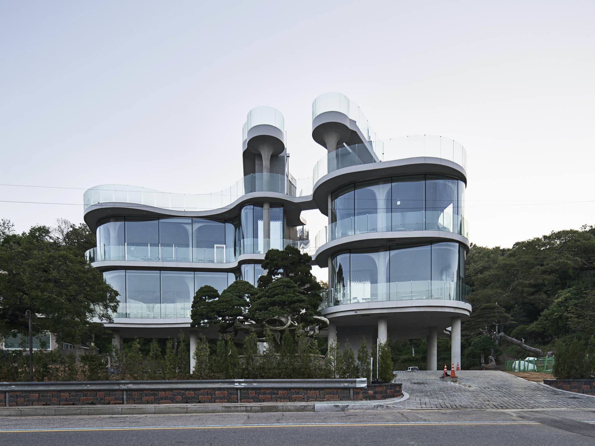 Two modern glass and steel buildings connected by a bridge, with multiple windows allowing natural light to enter the spaces