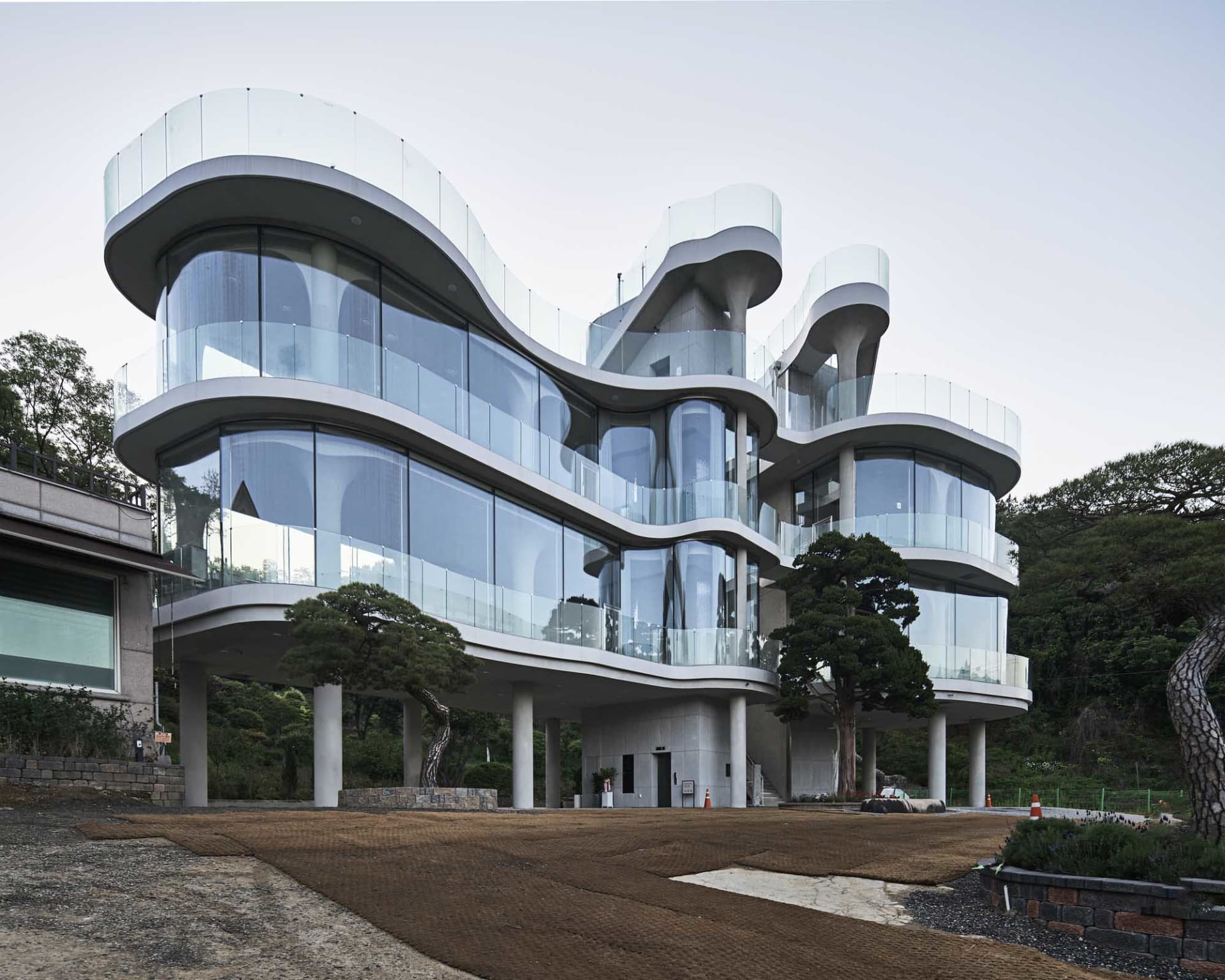 Modern office building with multiple levels, glass walls, and curved lines, featuring a contemporary design with emphasis on functionality and aesthetics
