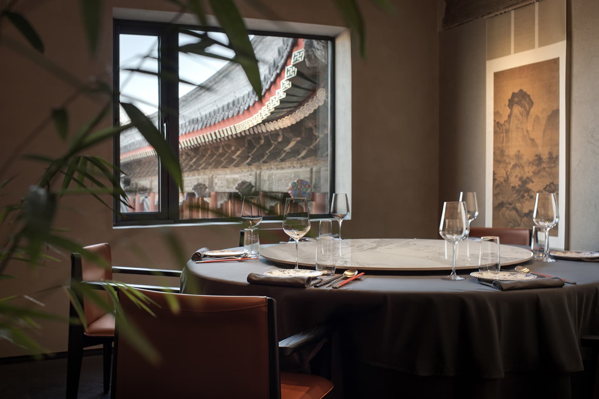 Sophisticated dining space with round tables, wine glasses, utensils, and comfortable seating