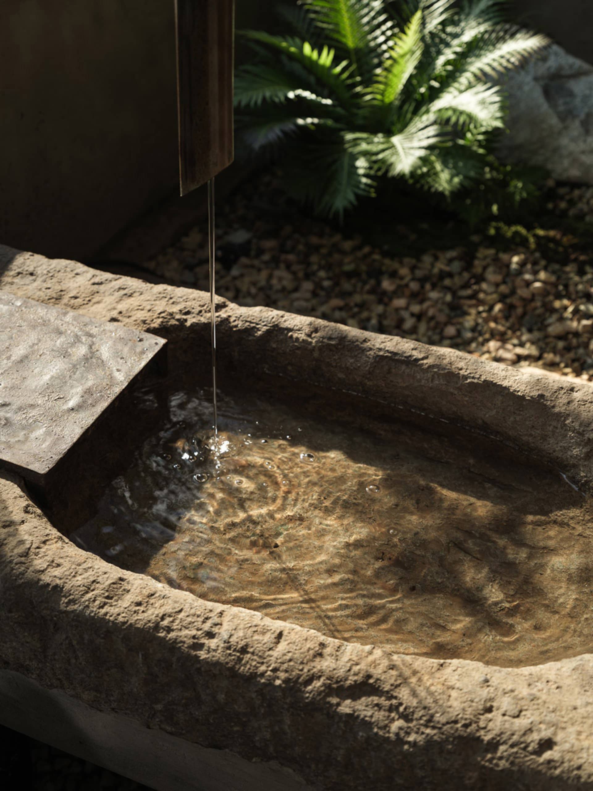 an old stone basin filled with water in a calm and serene courtyard or garden setting