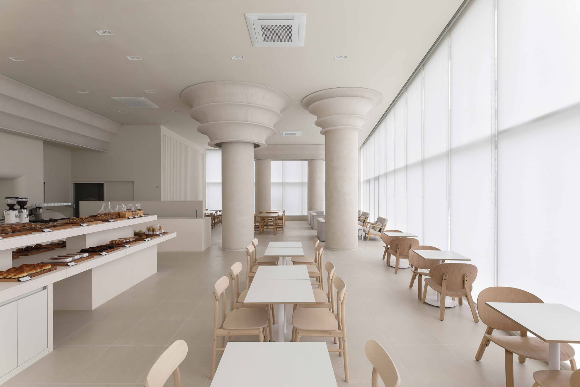 空置餐廳內部，白色牆面、餐桌與椅子，營造乾淨清爽的氛圍