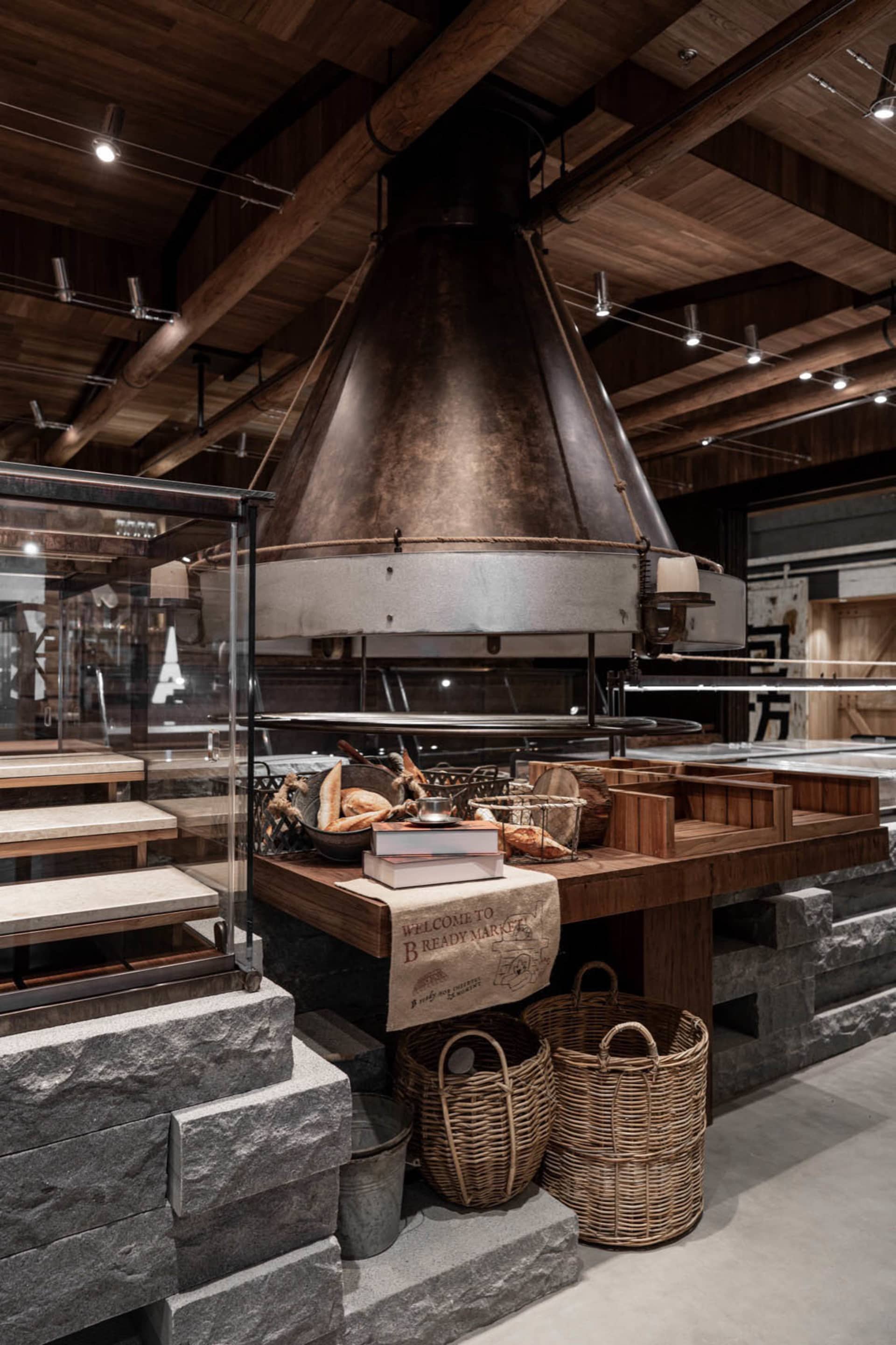 Warm and inviting restaurant interior with a central oven, books, and a cozy atmosphere