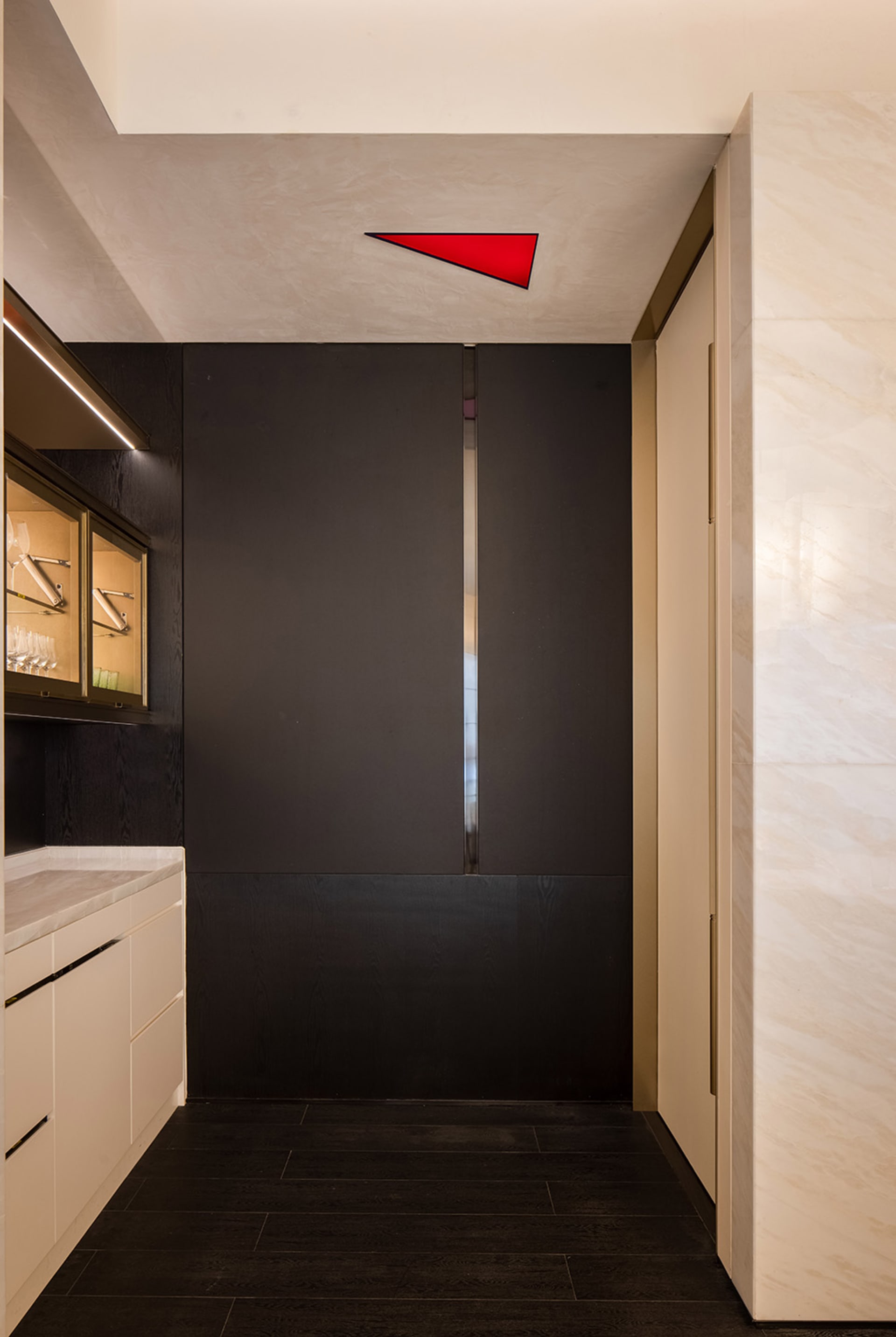 A narrow and dark hallway with a black doorway, flanked by two doors on either side