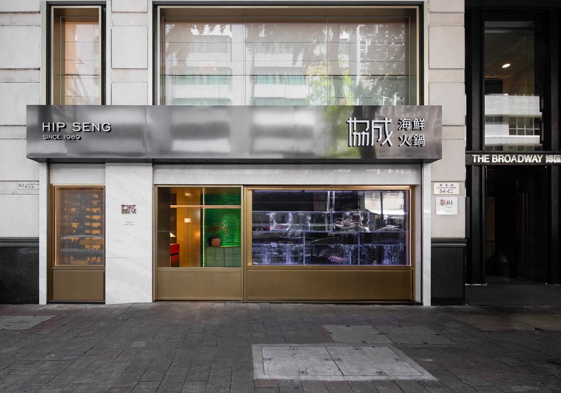 Spacious Asian restaurant with a glass front door, dining tables, chairs, and potted plants, creating a comfortable and inviting atmosphere