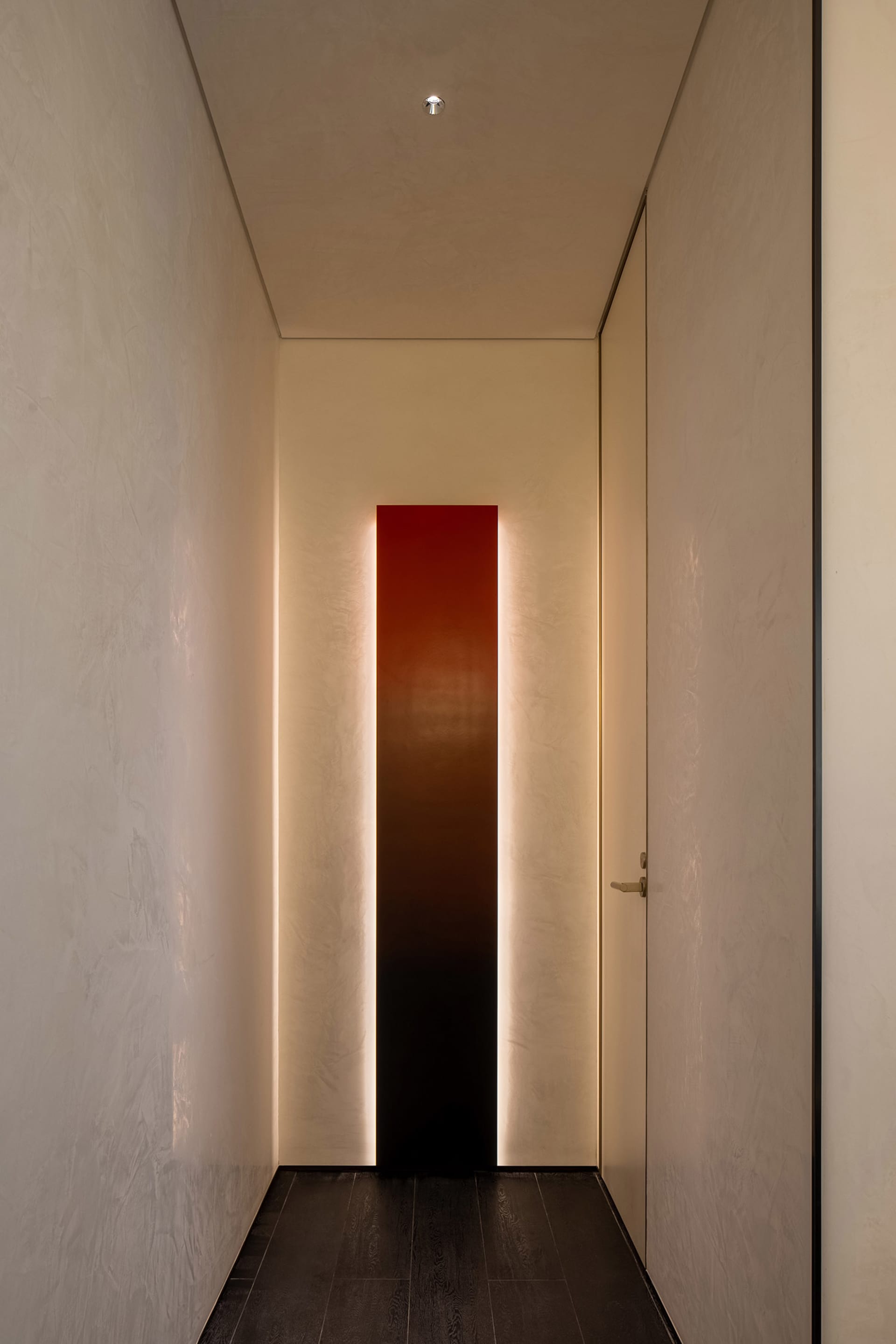A well-lit hallway with a white wall, two doors, and a red light strip, creating a bright atmosphere