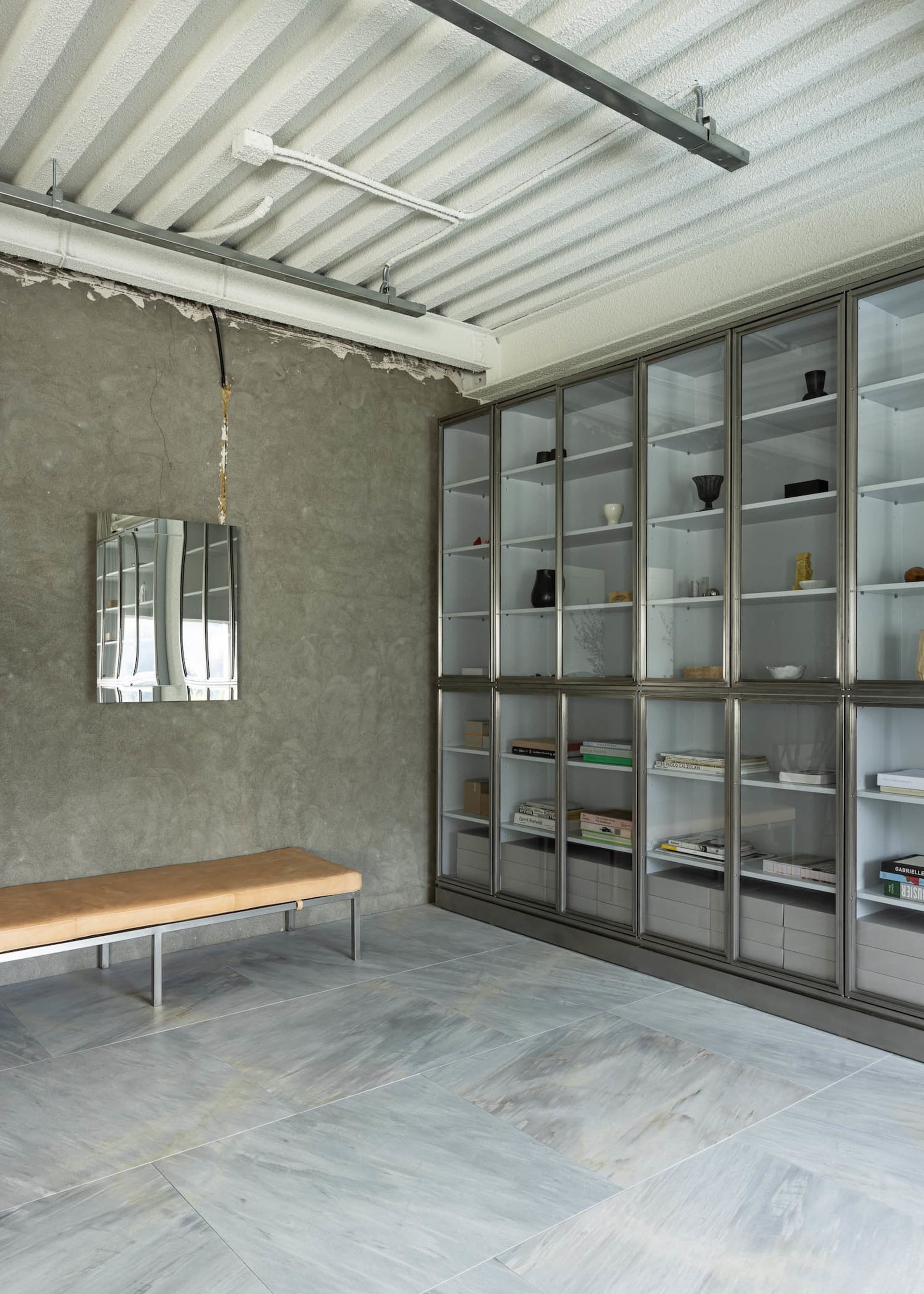 A modern bookshelf with glass shelves and decorative bowls, creating an inviting atmosphere for reading and relaxation