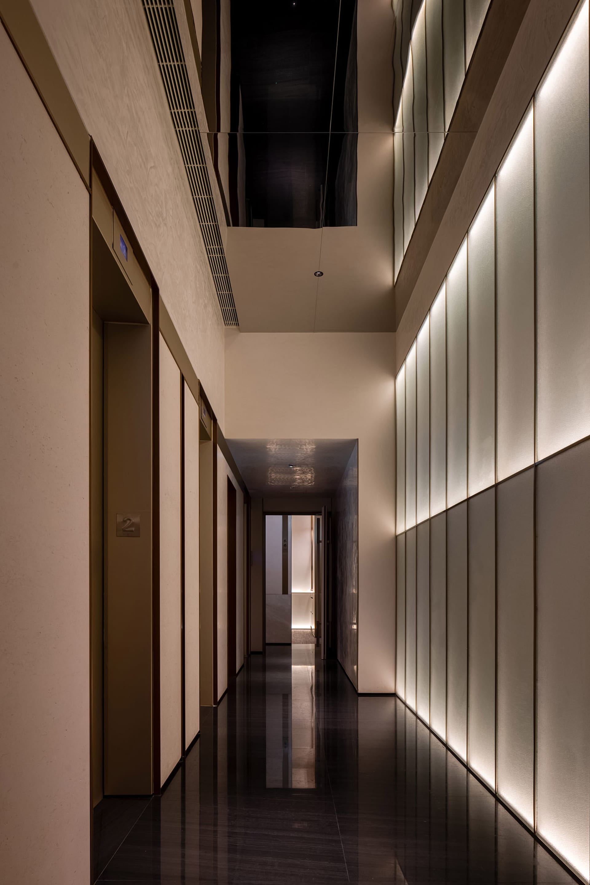 A clean and modern office hallway with white walls and floors, featuring three doors with different materials and ample lighting