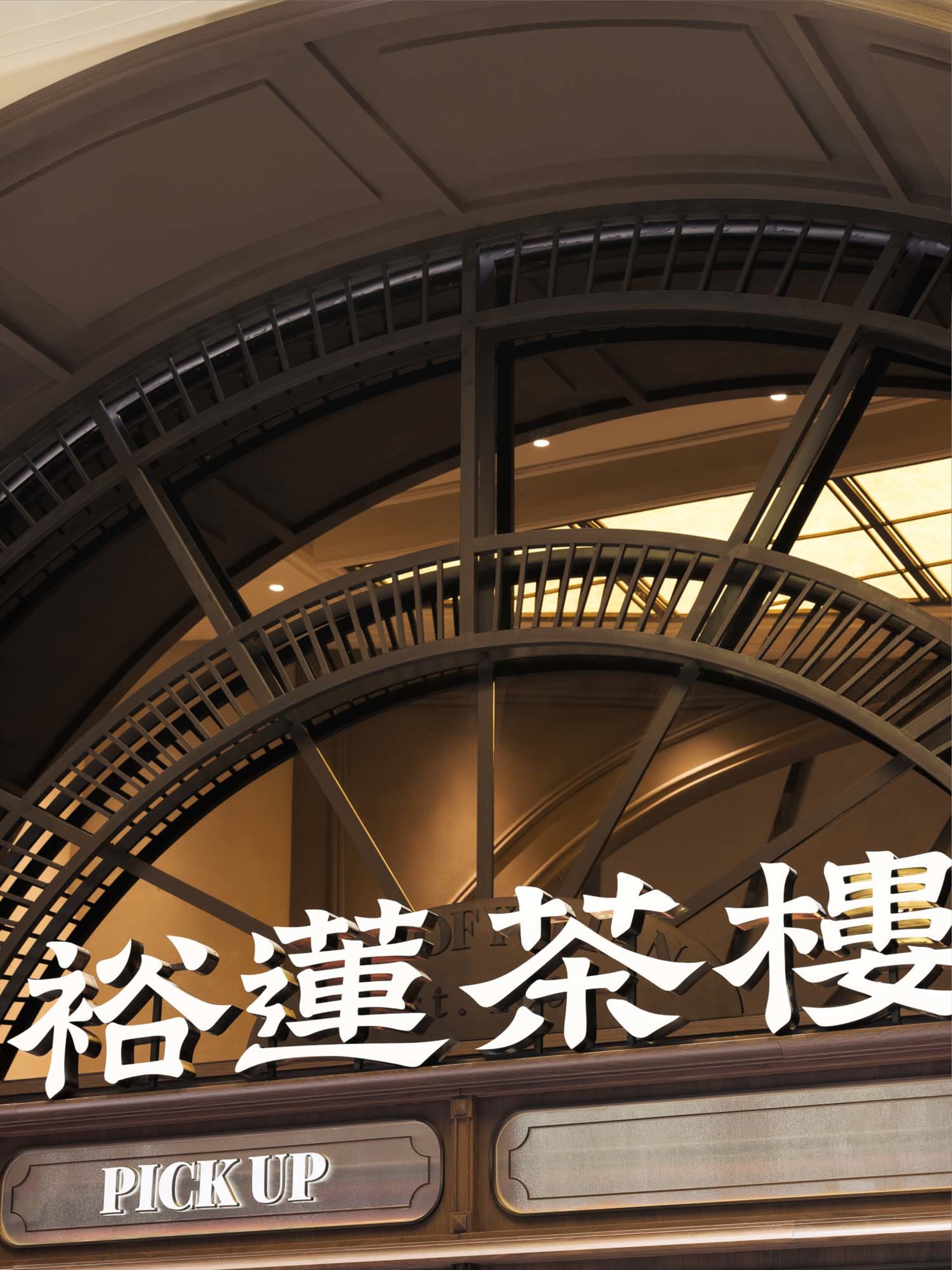 一座亞洲建築的大型拱門入口照片，配有金屬欄杆與兩段向上階梯
