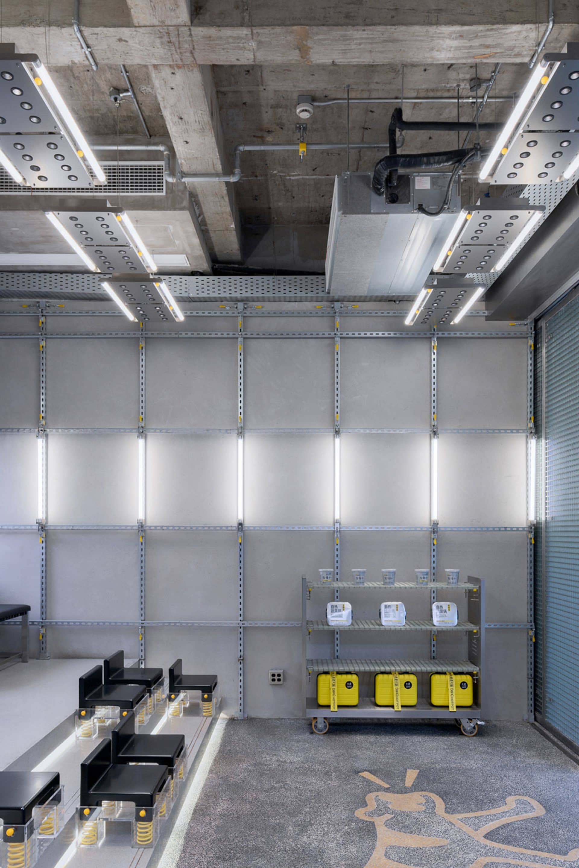 Industrial space with a concrete wall, metal beams, and functional furniture, giving a utilitarian atmosphere