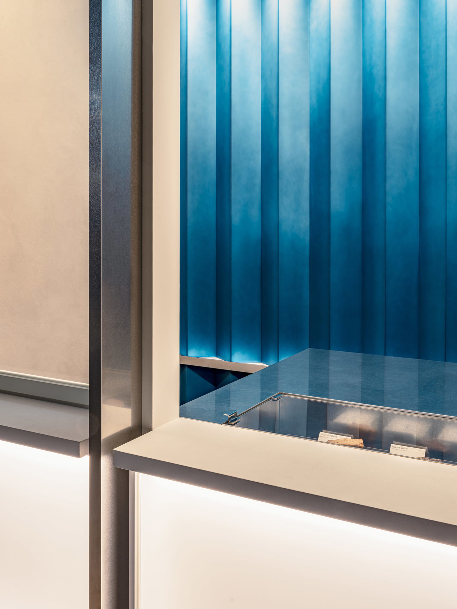 A well-organized restaurant counter with a glass front, featuring multiple bottles and cups, in a professional environment