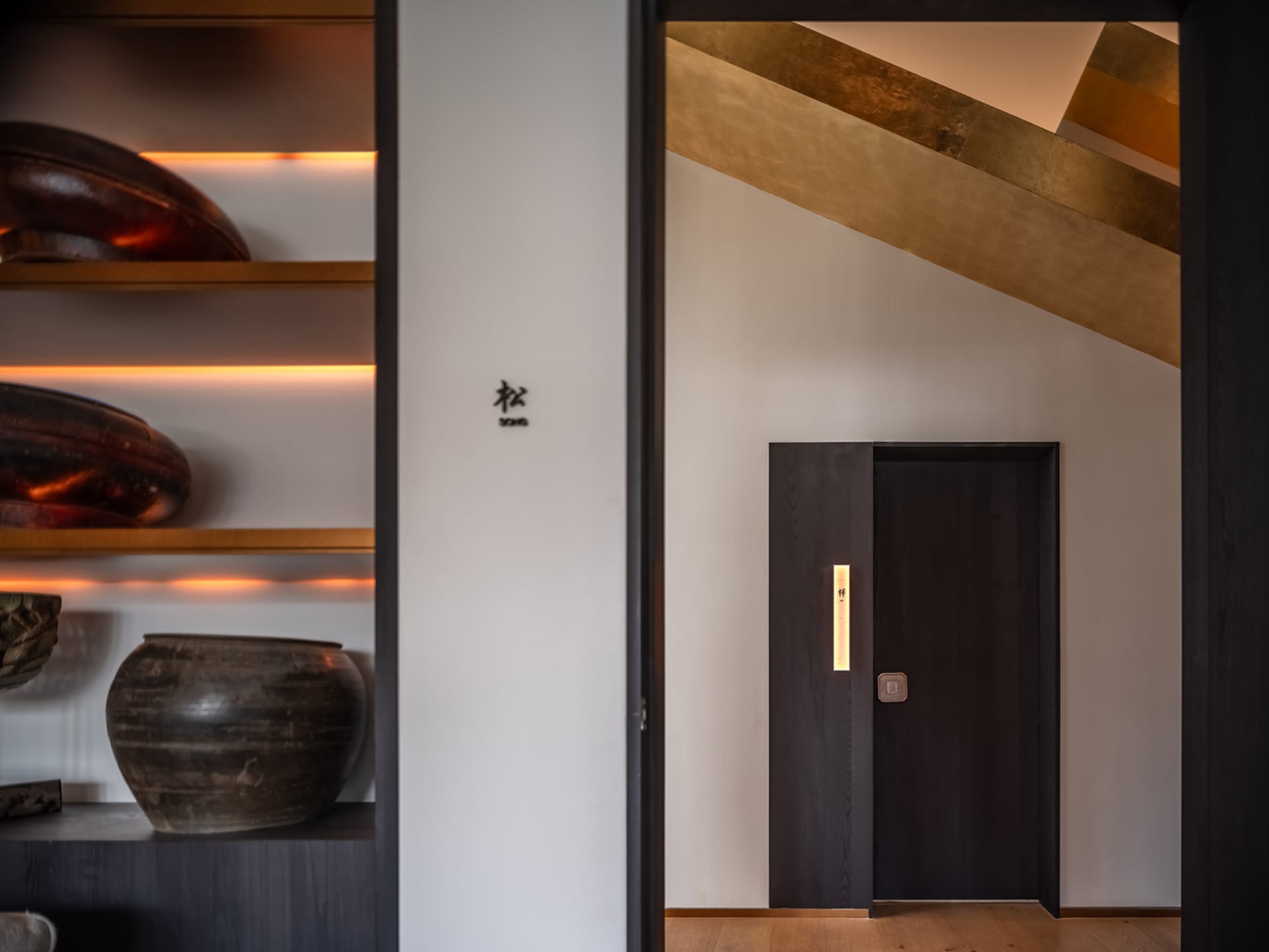 A clean and modern hallway with a white wall, two doors, and well-lit space