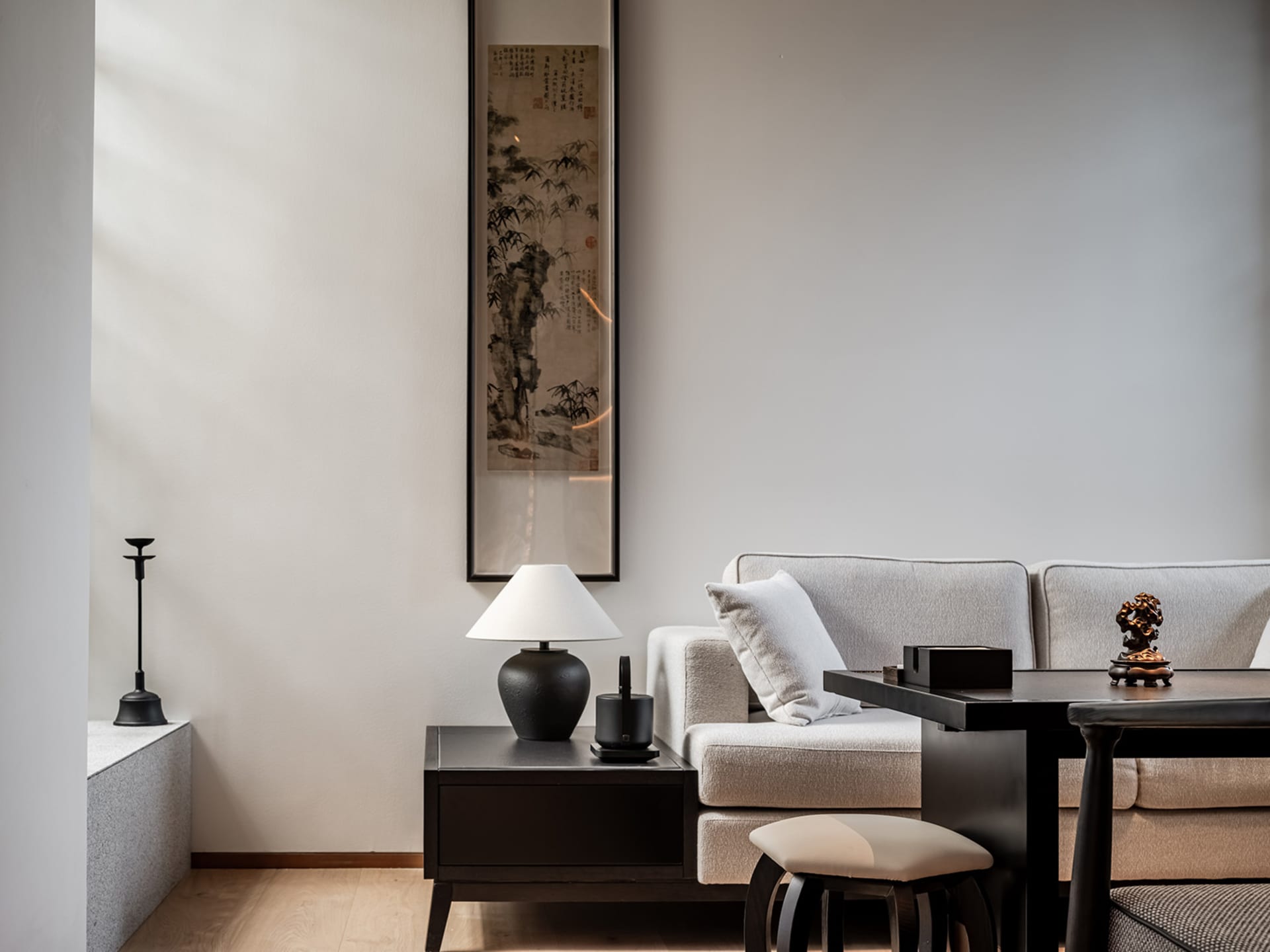 Modern living room with a couch, chair, coffee table, and picture on the wall, featuring grey walls and wooden floors
