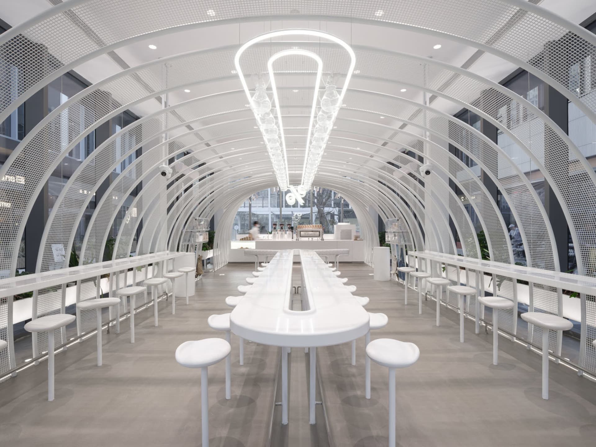 A bright and inviting dining area with multiple white tables and chairs, designed for social gatherings or events