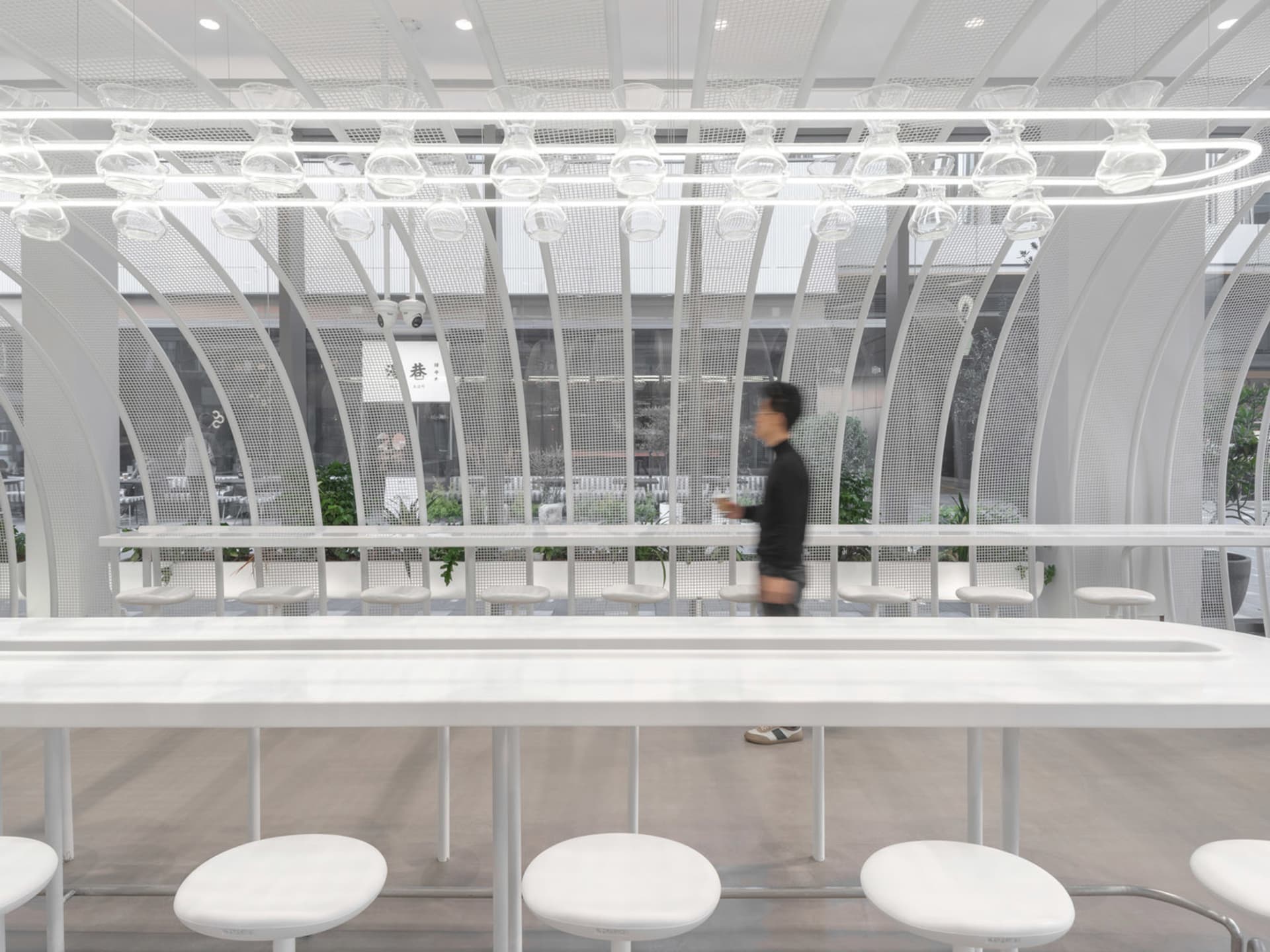 Modern restaurant interior with a long bar, dining tables, and comfortable seating for guests