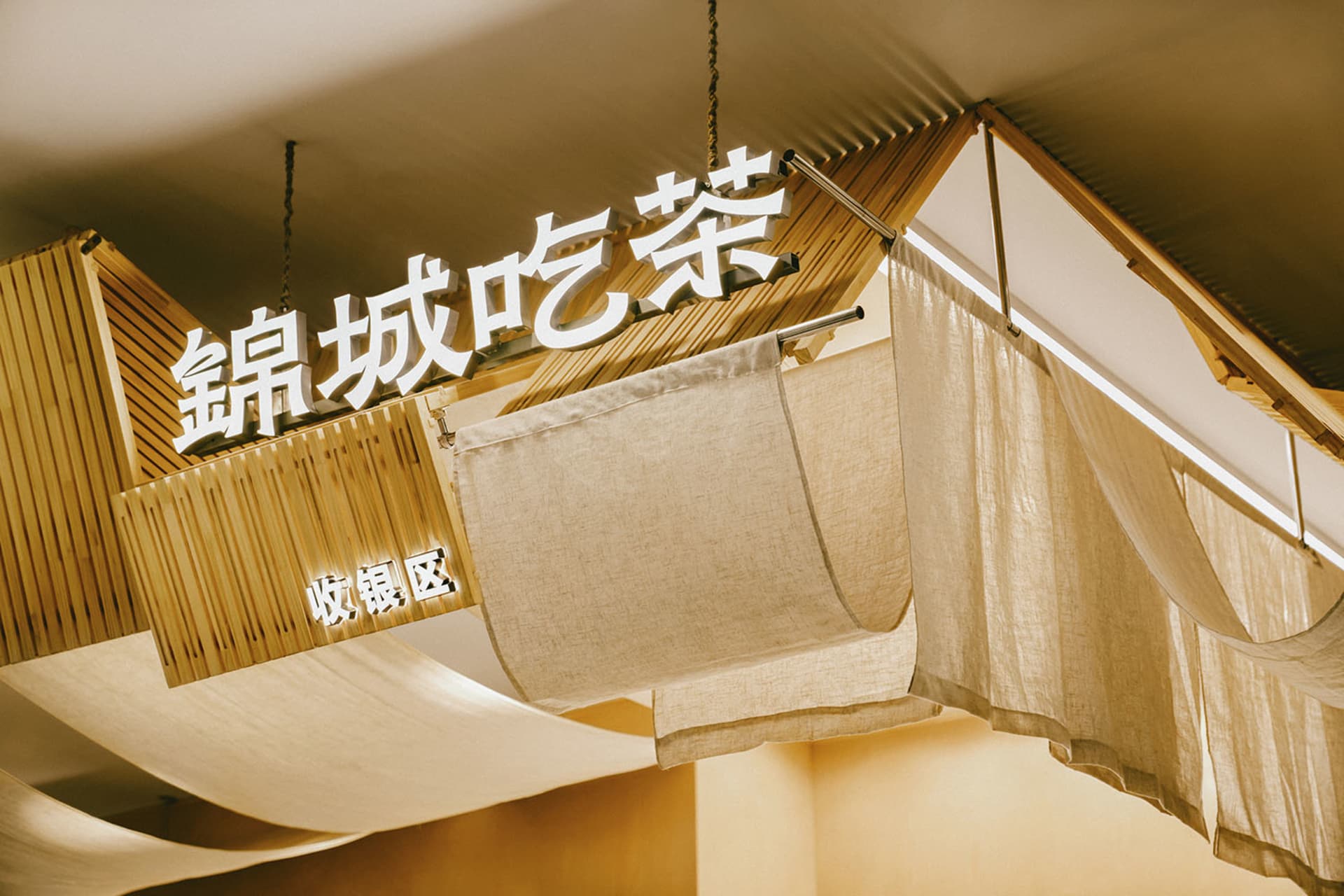 燈光明亮的亞洲餐廳，擁有竹牆、懸掛布藝裝飾與溫暖氛圍