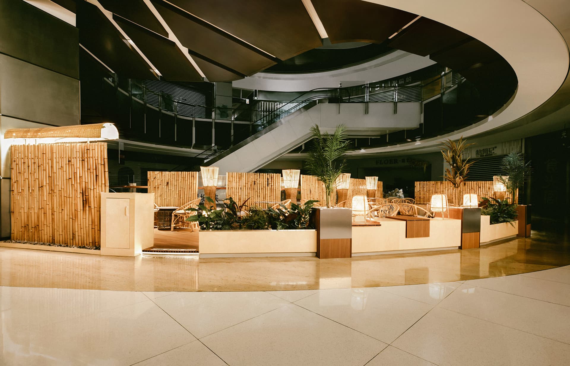 A welcoming indoor space with a circular staircase surrounded by plants, decorative elements, and two benches, creating a lush atmosphere