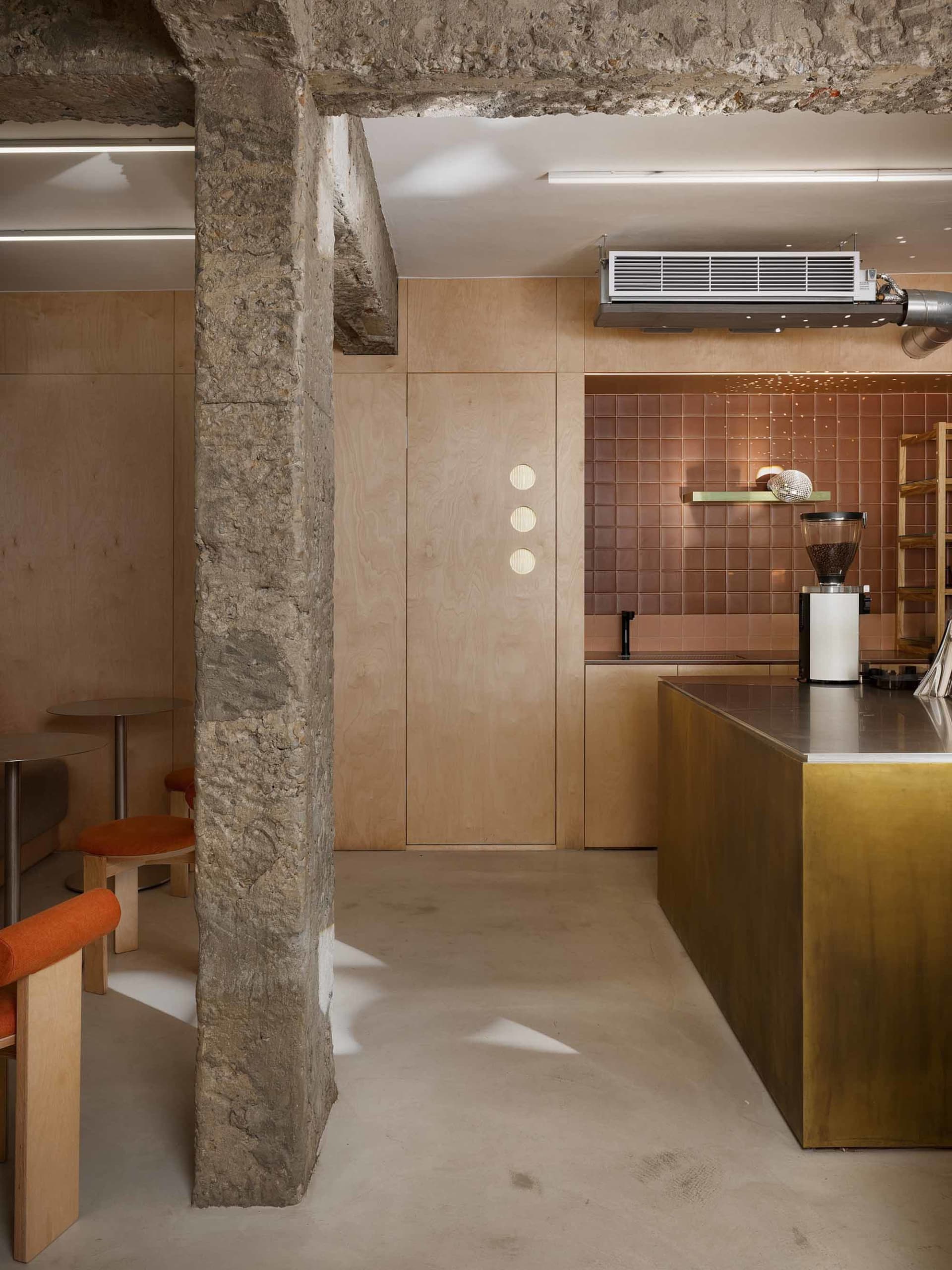 Warm kitchen space with a stone wall, wooden cabinets, and a countertop, featuring a dining table, chairs, and a sink