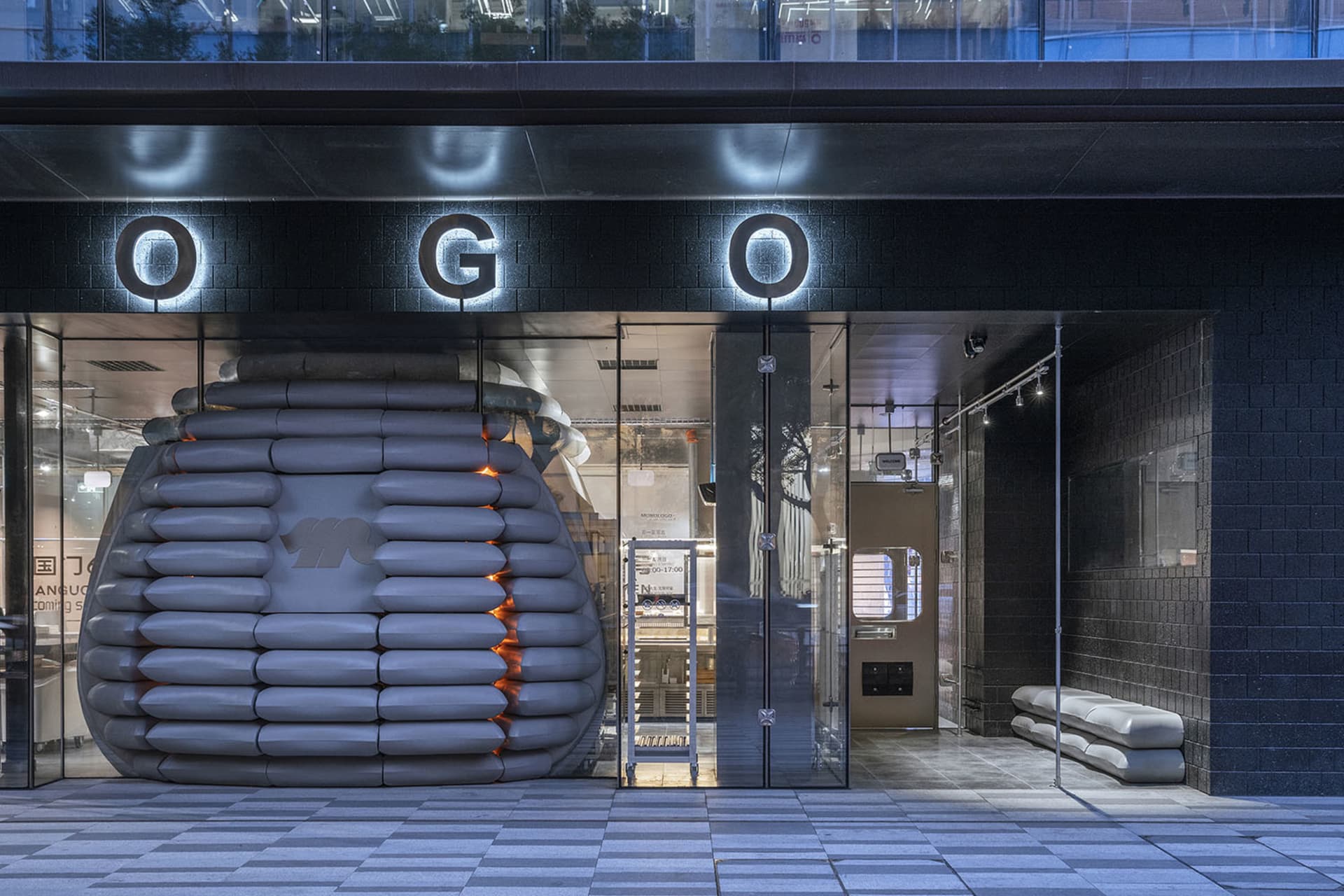 A storefront interior with a large inflatable baseball glove as its centerpiece, surrounded by doors and a playful atmosphere