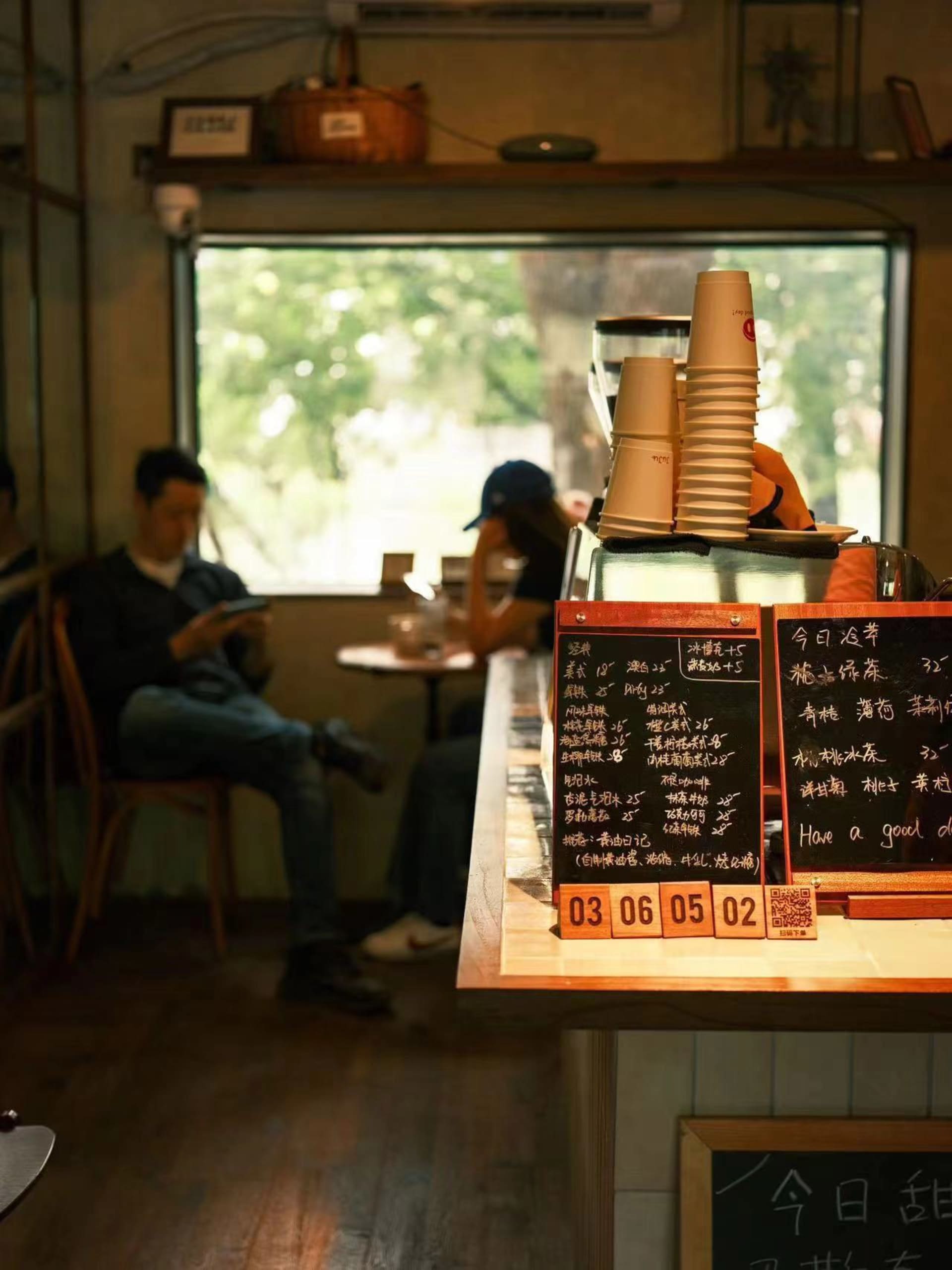 A warm and inviting restaurant interior with a wooden counter and chairs, featuring three people engaged in conversation