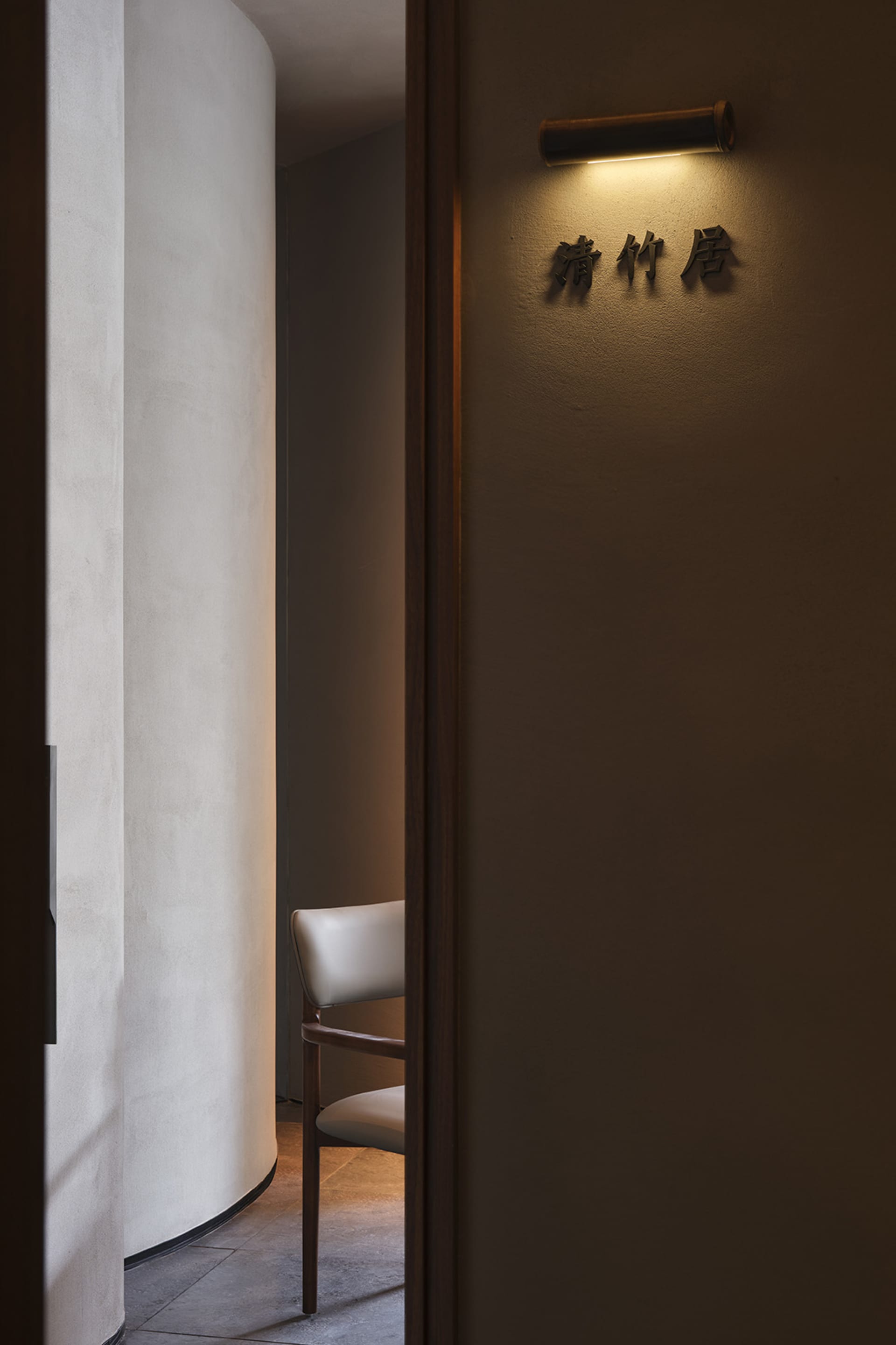 A cozy living space with a wooden chair and a doorway leading to another room, suggesting a warm and inviting atmosphere