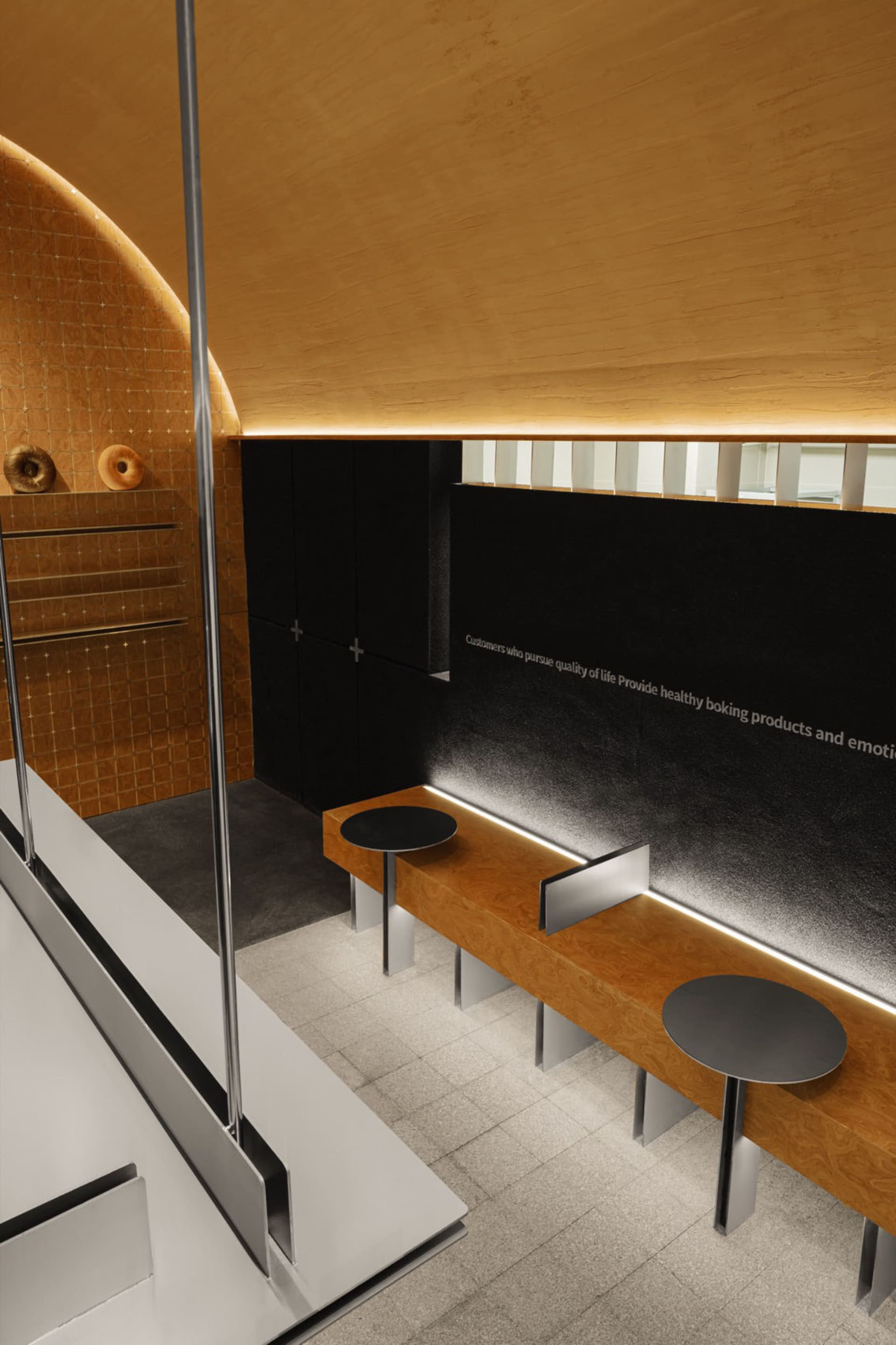 A restaurant dining area with tables, chairs, a couch, and writings on the walls, set in a well-lit space