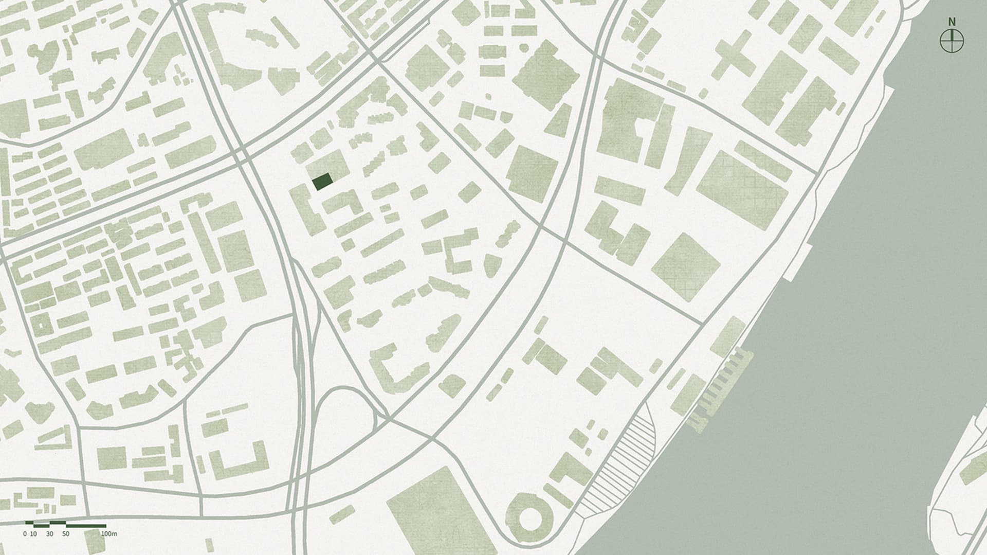 Aerial view of a city street intersection with various buildings, a green roof, and traffic lights
