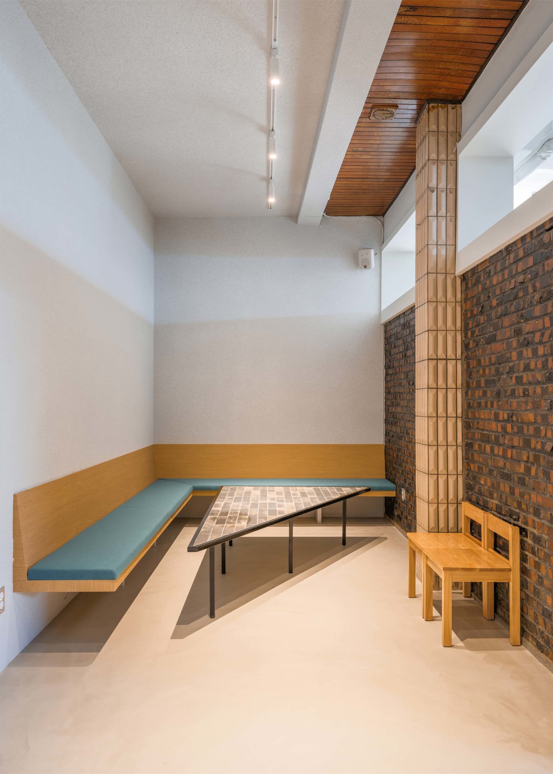 Cozy living and dining space with two benches, a dining table, and chairs, surrounded by warm and inviting atmosphere