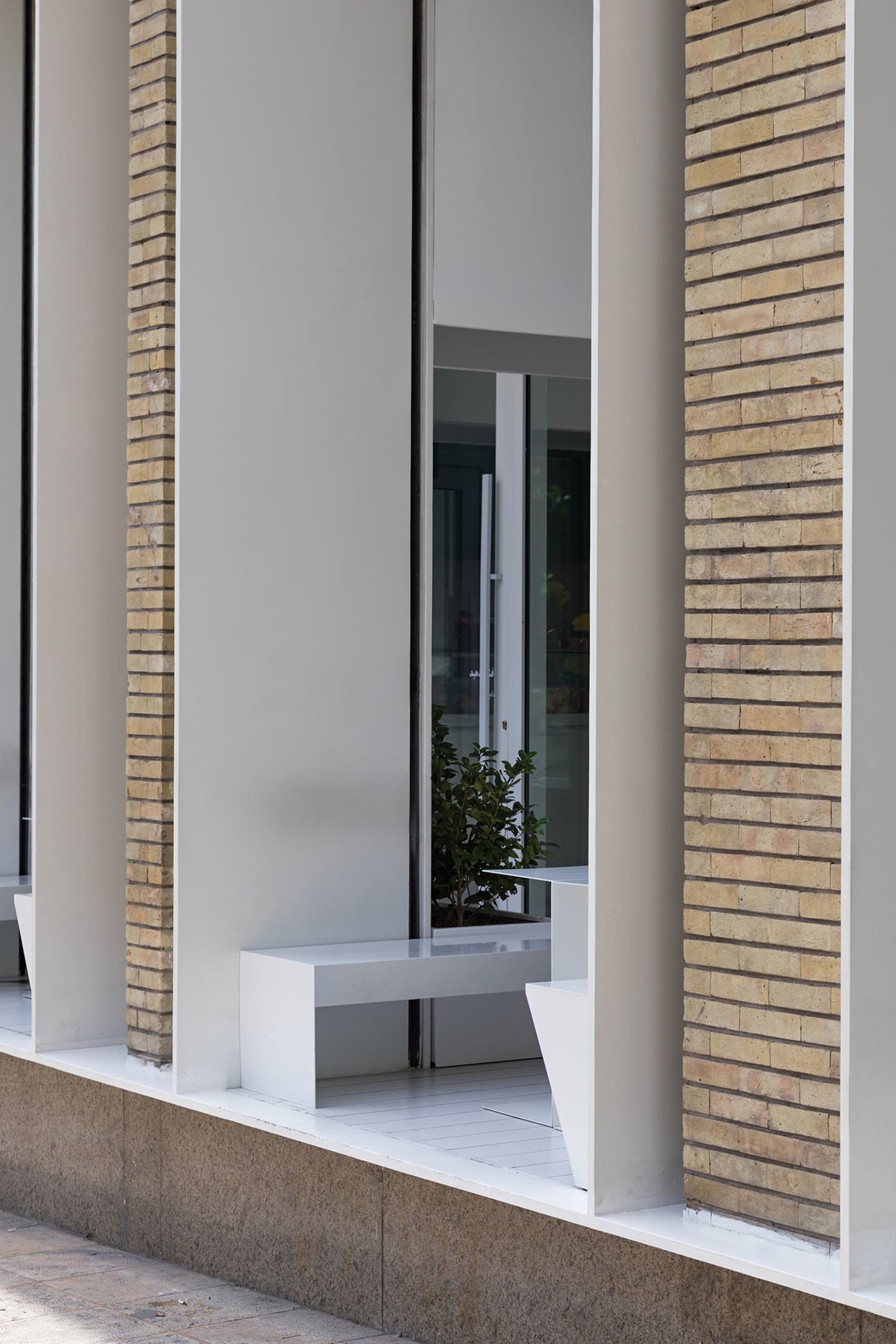 A brick building facade with three benches in front, creating a calm and inviting atmosphere