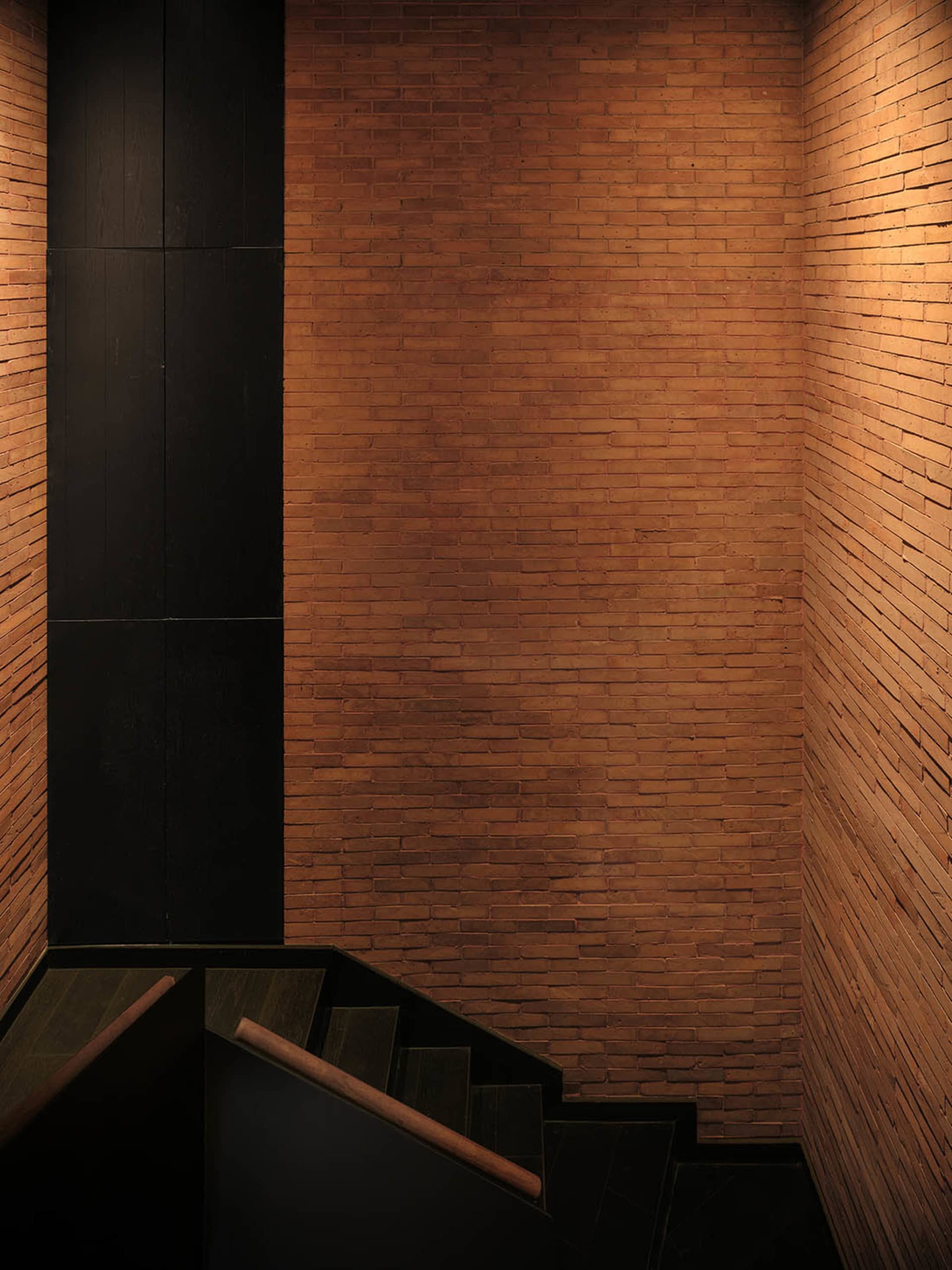 Empty hallway with wooden walls and steps leading upwards, creating a warm and inviting atmosphere