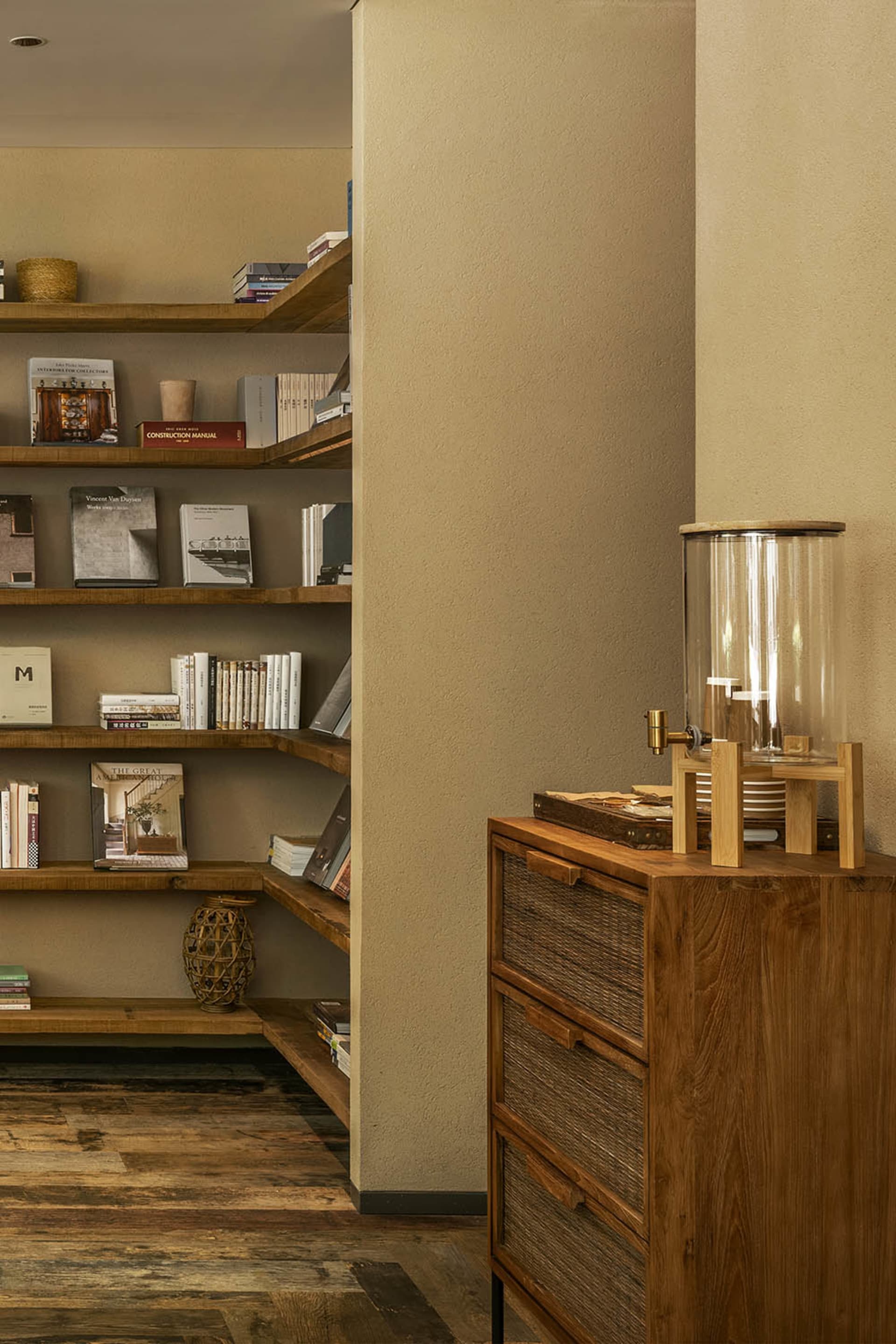 A wooden bookshelf filled with various books in different sizes and colors, creating a cozy and intellectual environment