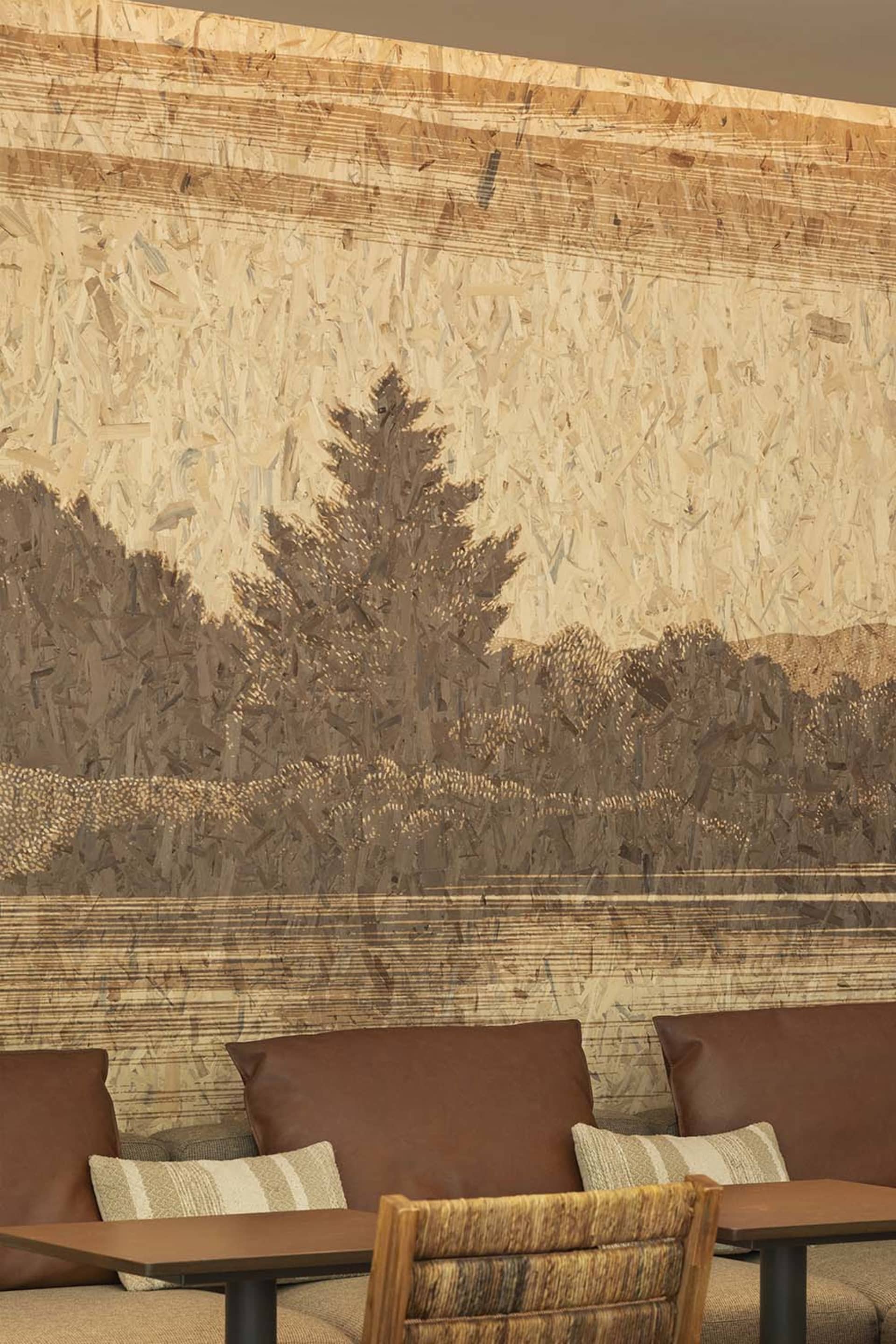 Warm and inviting living room with a tree in the center, featuring three chairs and a cozy atmosphere