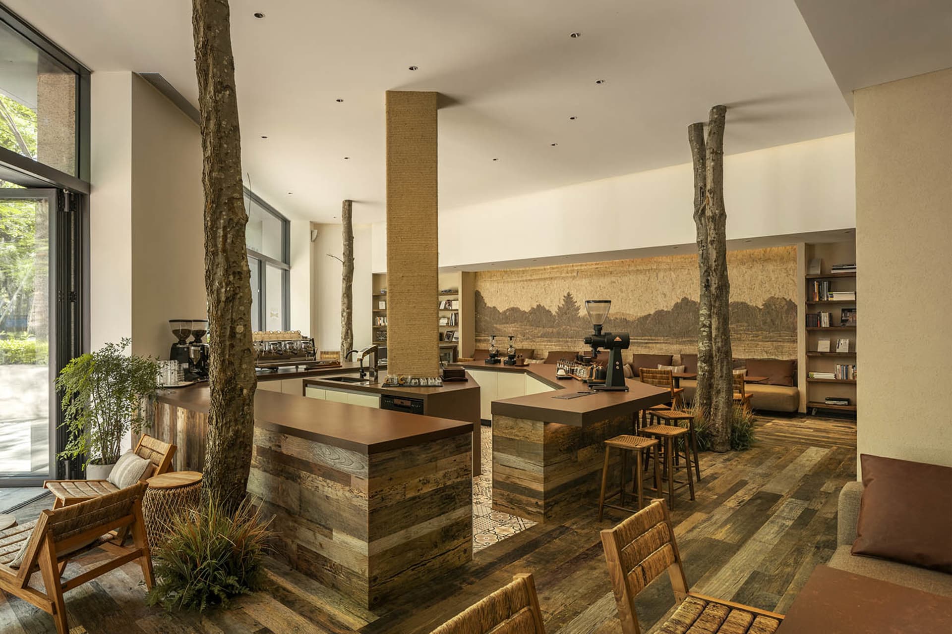 A warm and inviting cafe interior with wooden tables, chairs, and walls, featuring multiple dining tables and a cozy atmosphere