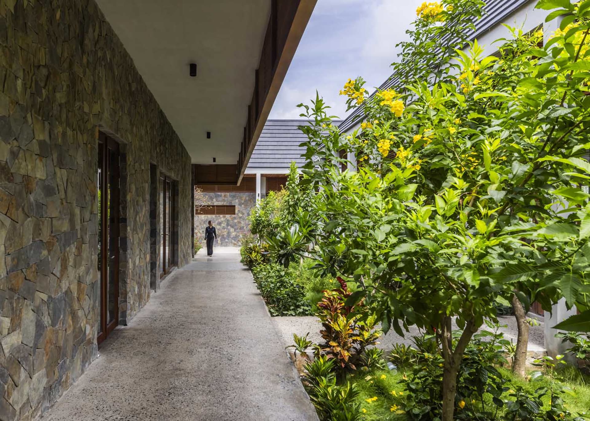 A house with a walkway leading to its entrance, featuring a patio area with potted plants and a pleasant atmosphere