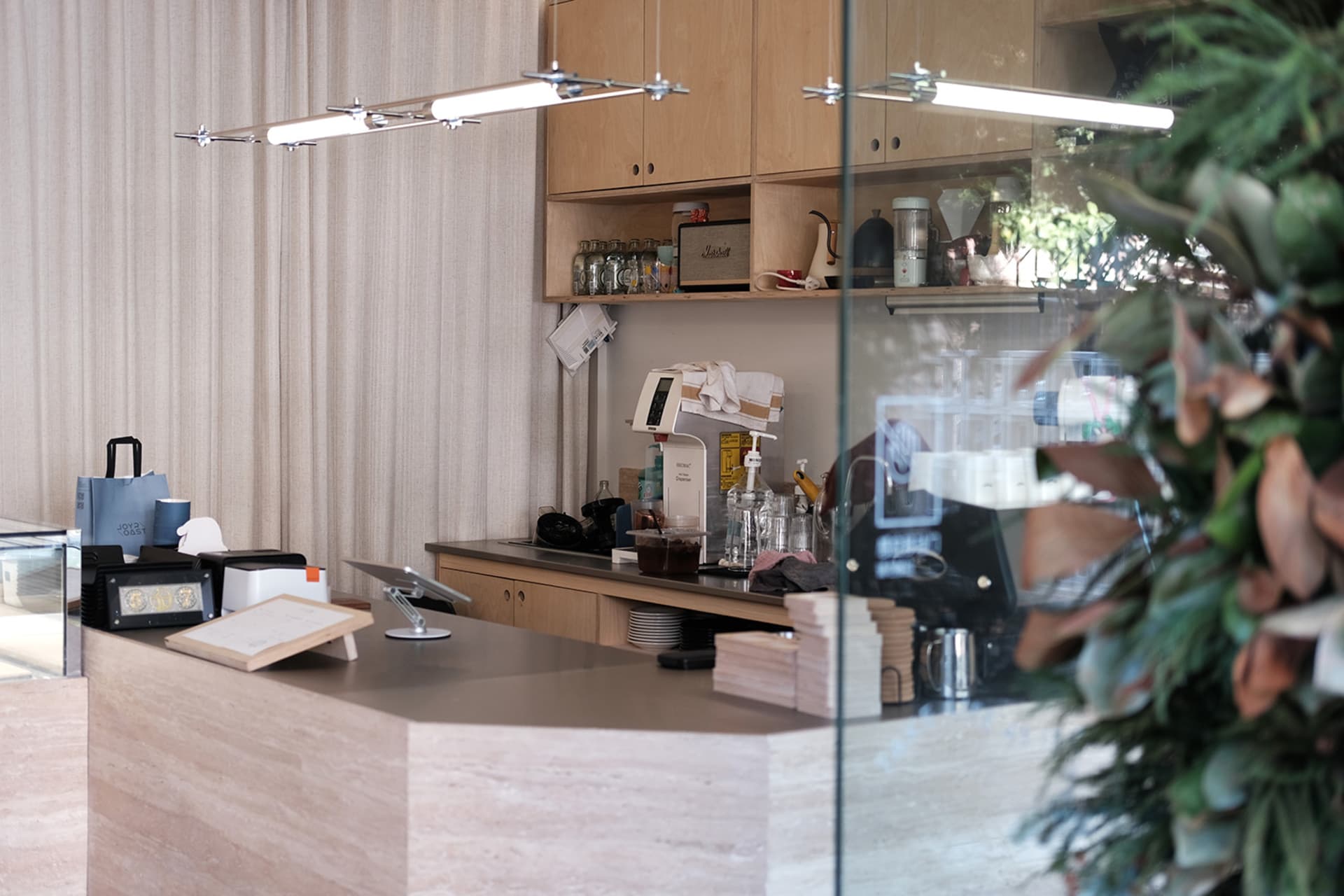 A casual office kitchen area with a countertop featuring cups, bottles, and a bowl, indicating a space for both work and refreshments