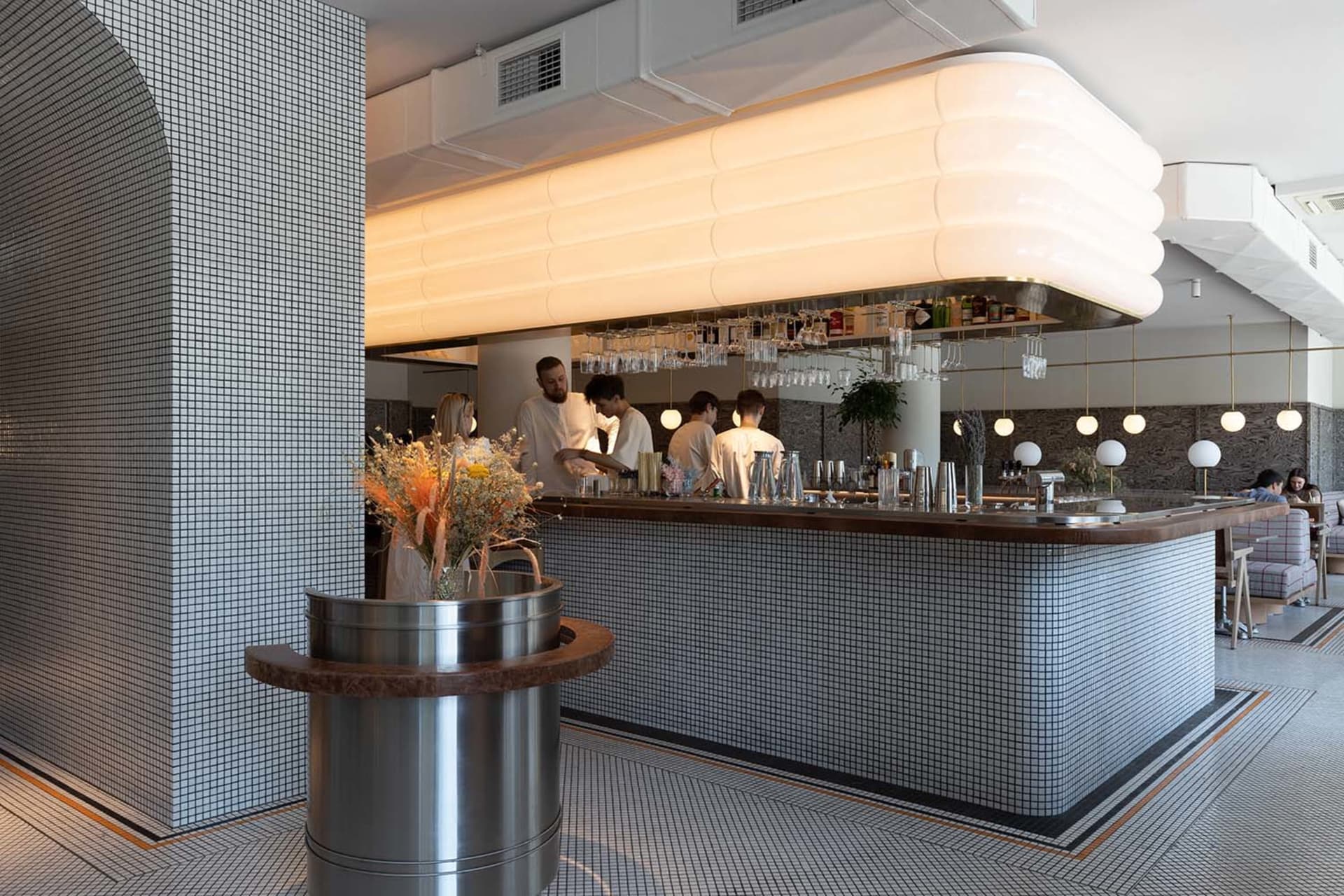 A modern restaurant bar with a countertop, wine glasses, and bottles displayed in a sophisticated and inviting atmosphere