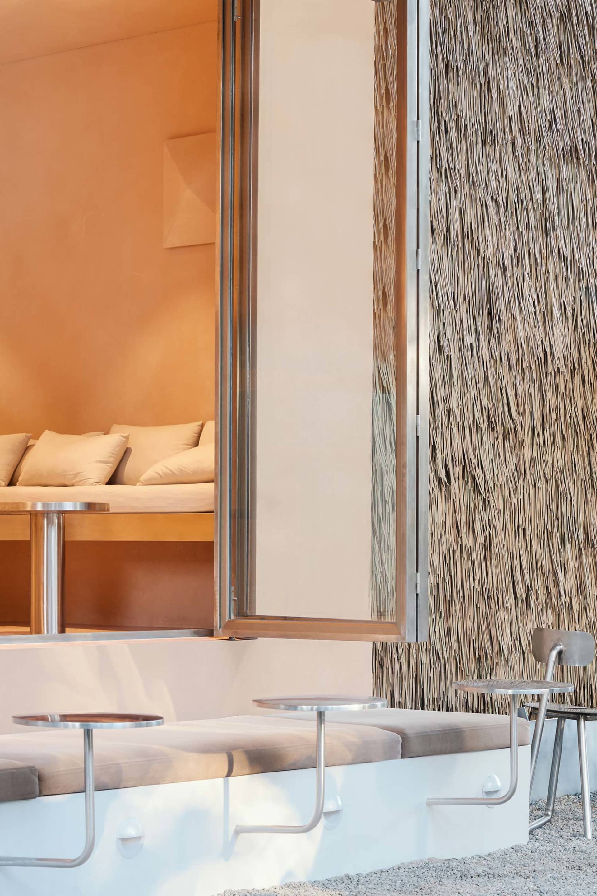 A modern living area with two couches, two chairs, and a dining table, featuring textured wallpaper in a combination of white and brown tones