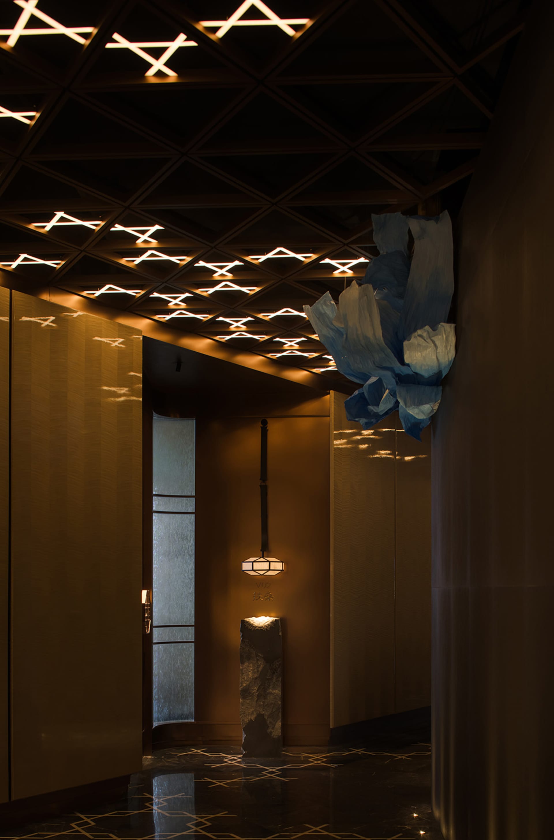 A warm and inviting room with a brown wall, a blue flowery fabric, and two light sources