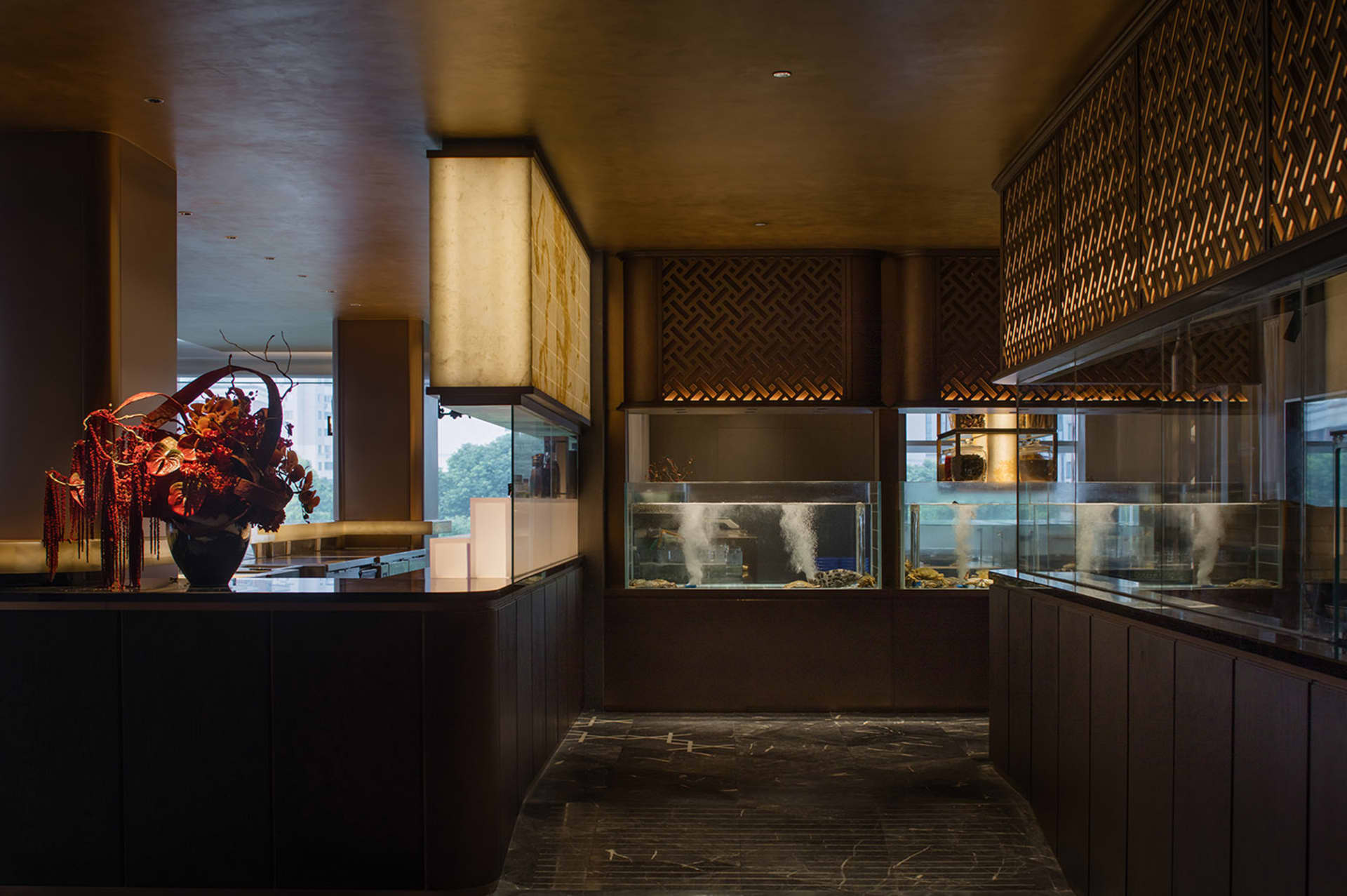 A luxurious restaurant interior with an aquarium centerpiece, surrounded by decorative elements, plants, and bottles, creating a sophisticated ambiance