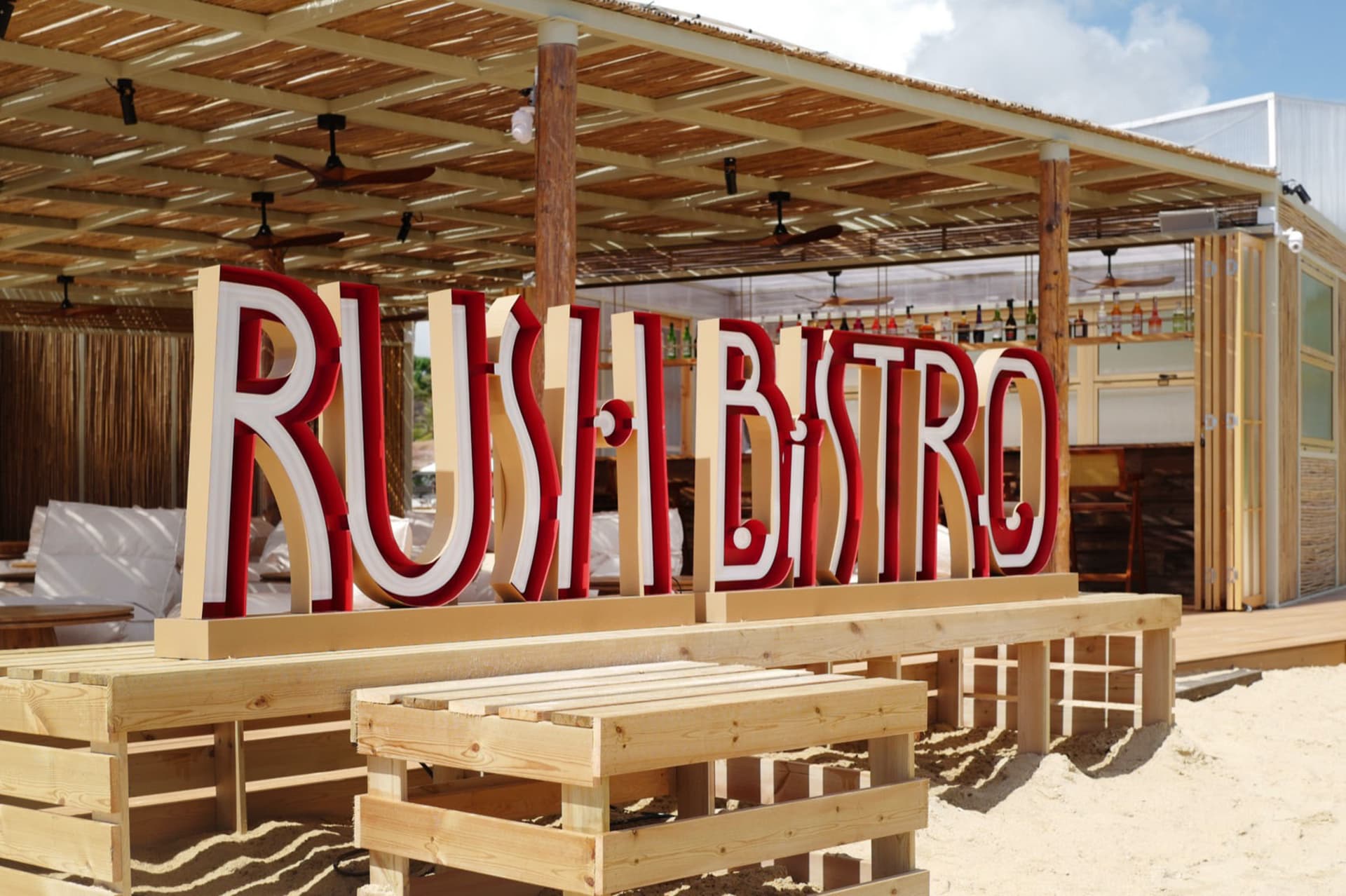 木構休閒戶外餐廳，配有長椅與「Rush Bistro」招牌