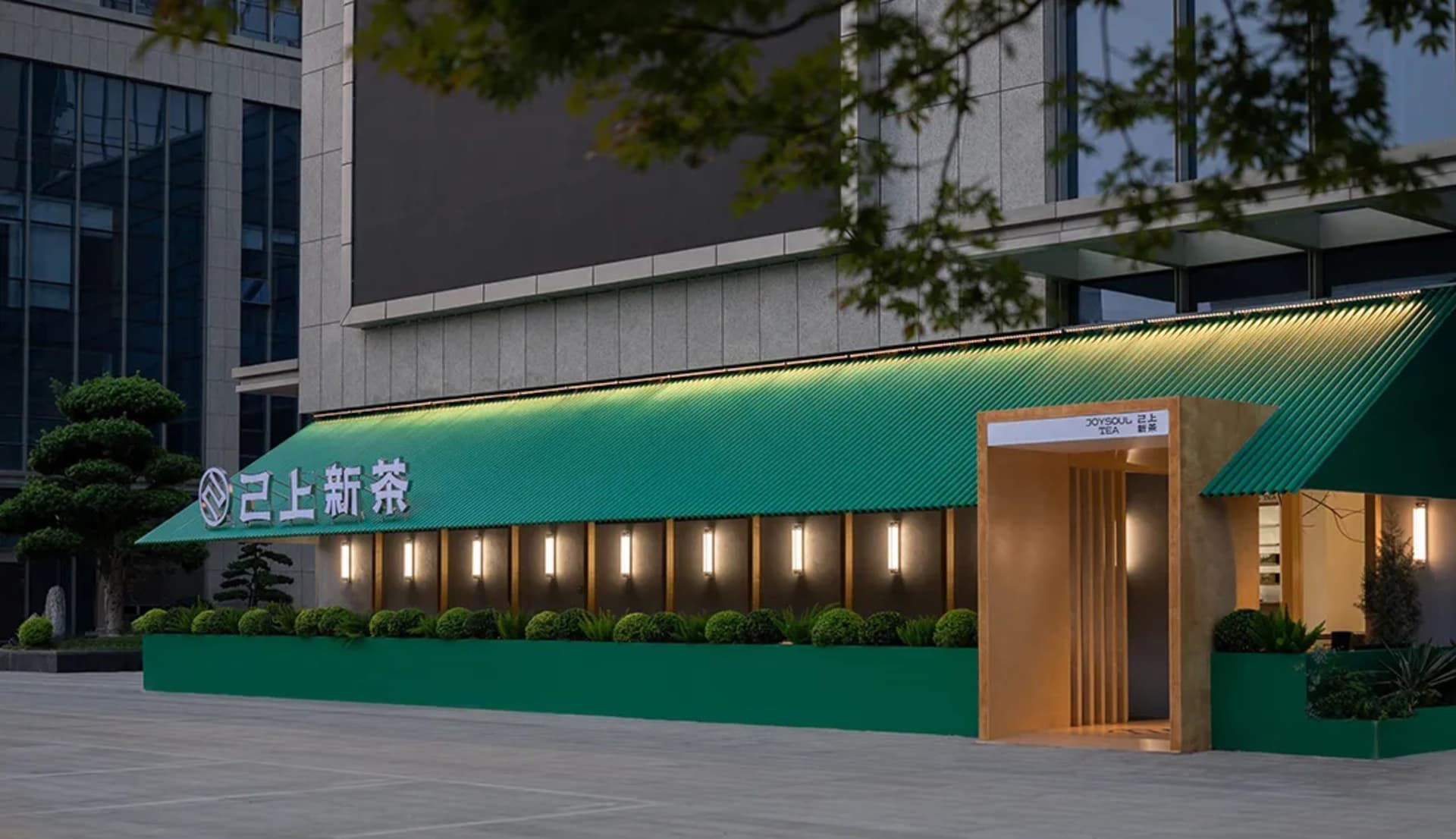 現代亞洲餐廳擁有綠色牆面、綠色屋頂，以及入口周圍的盆栽植物，營造出溫馨時尚的氛圍