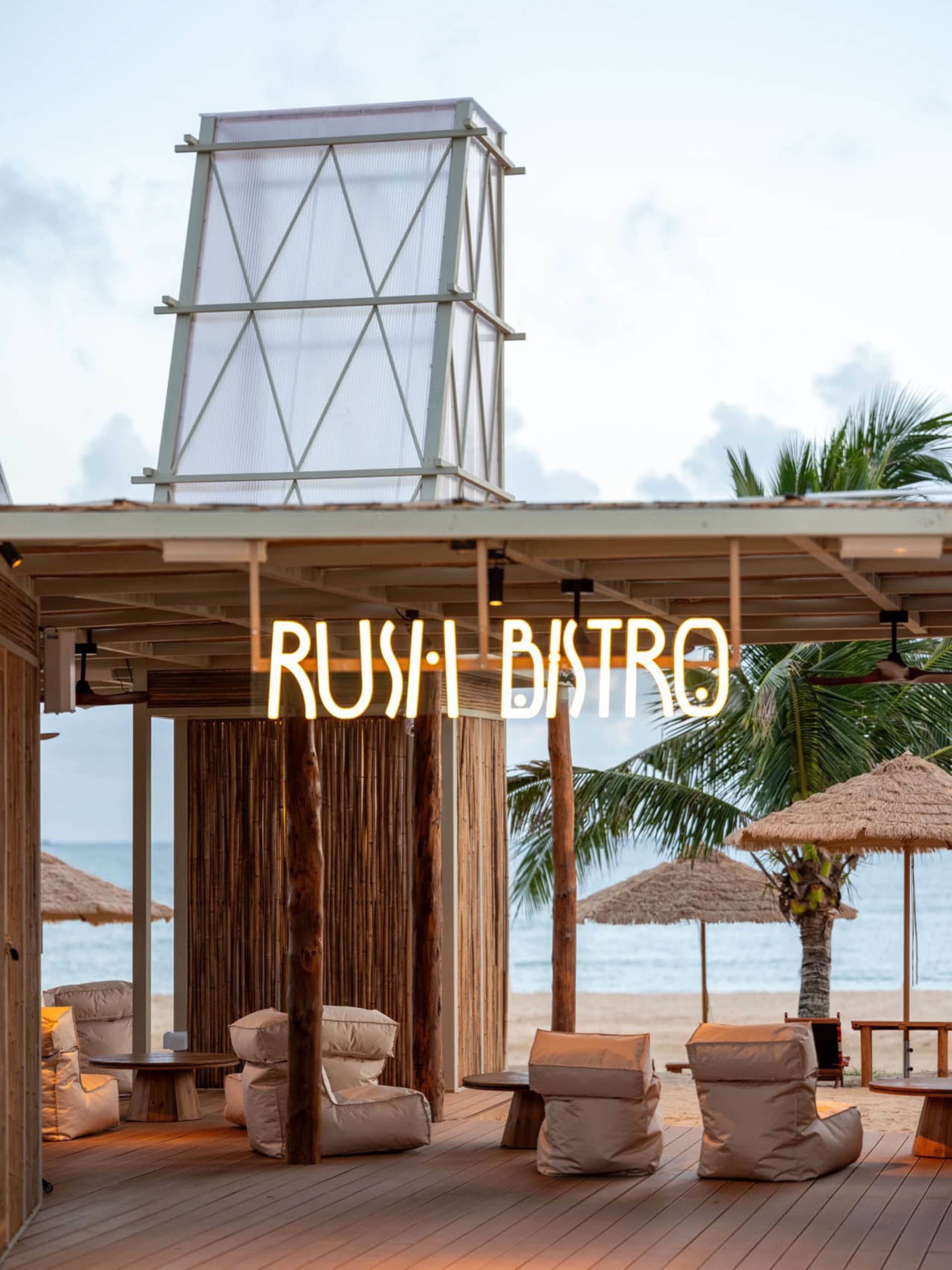An outdoor patio area with chairs and tables under umbrellas, creating a relaxed and inviting atmosphere for dining or socializing