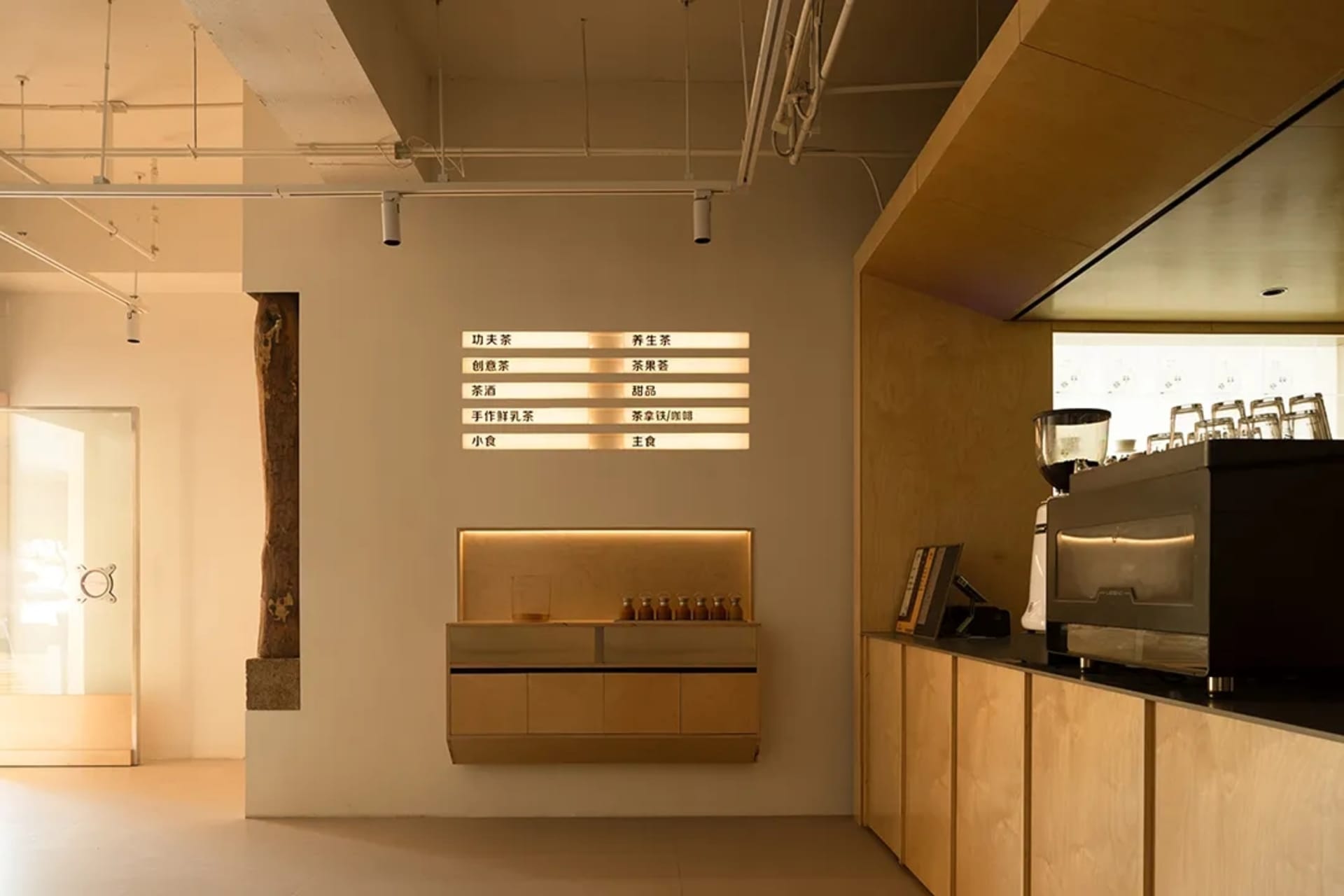 A restaurant counter with bottles, cups, and bowls on display, a coffee maker in the background, and an inviting atmosphere
