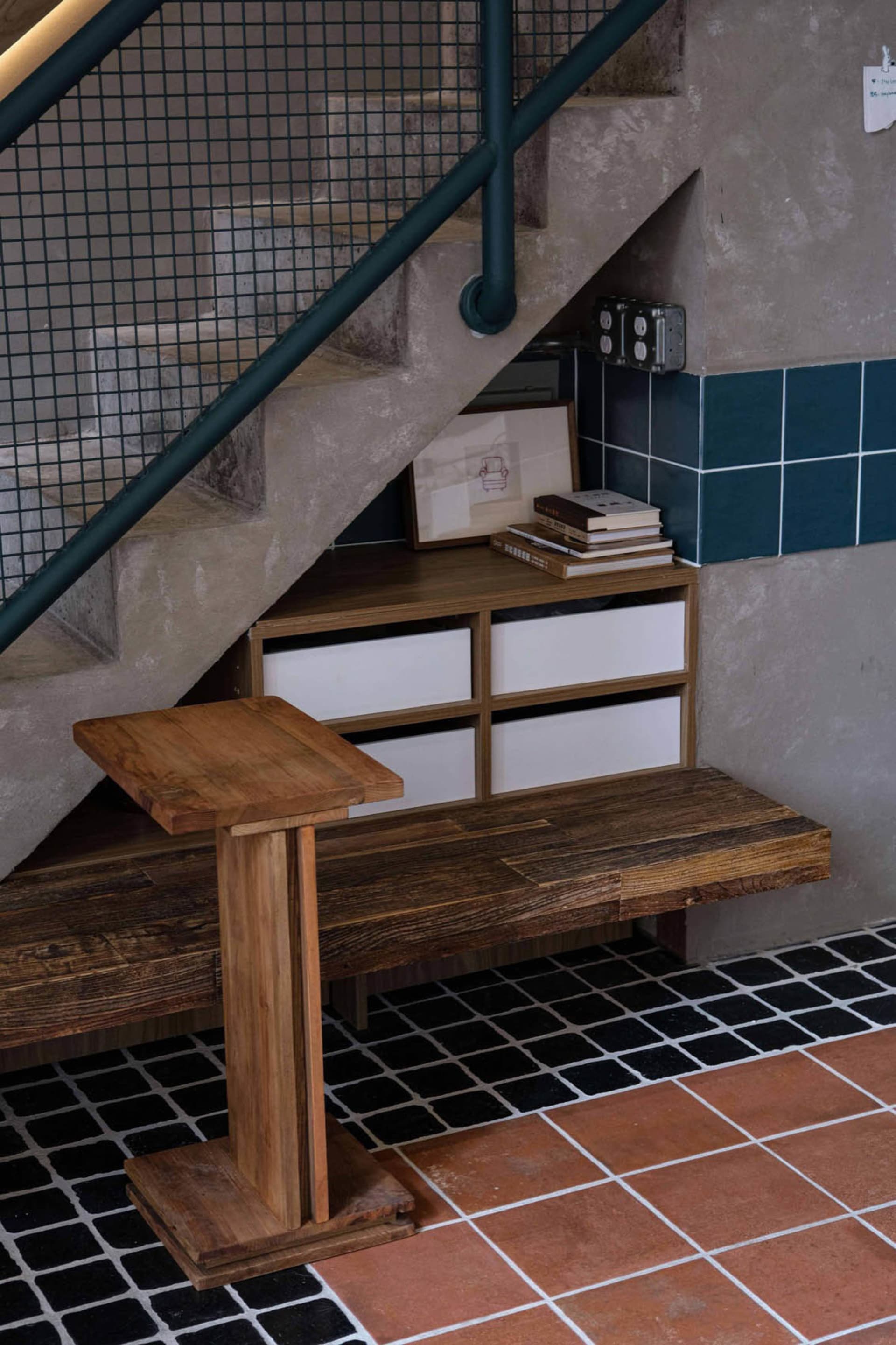 A cozy interior stairwell with a wooden bench and books, leading to a multi-level living space