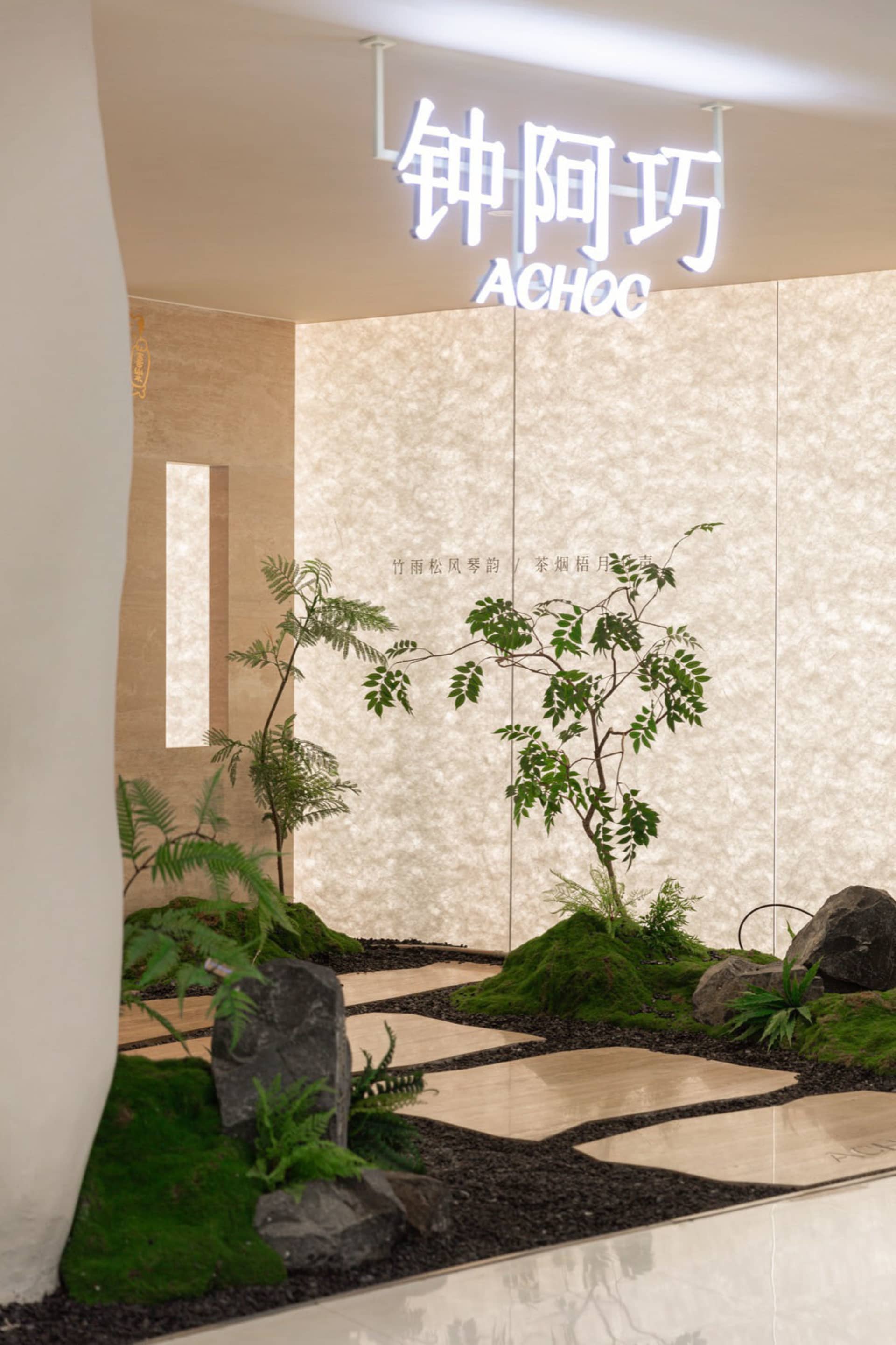 A serene indoor space with a large white wall featuring potted plants of varying heights, creating a lush atmosphere with two vases placed on either side of the wall