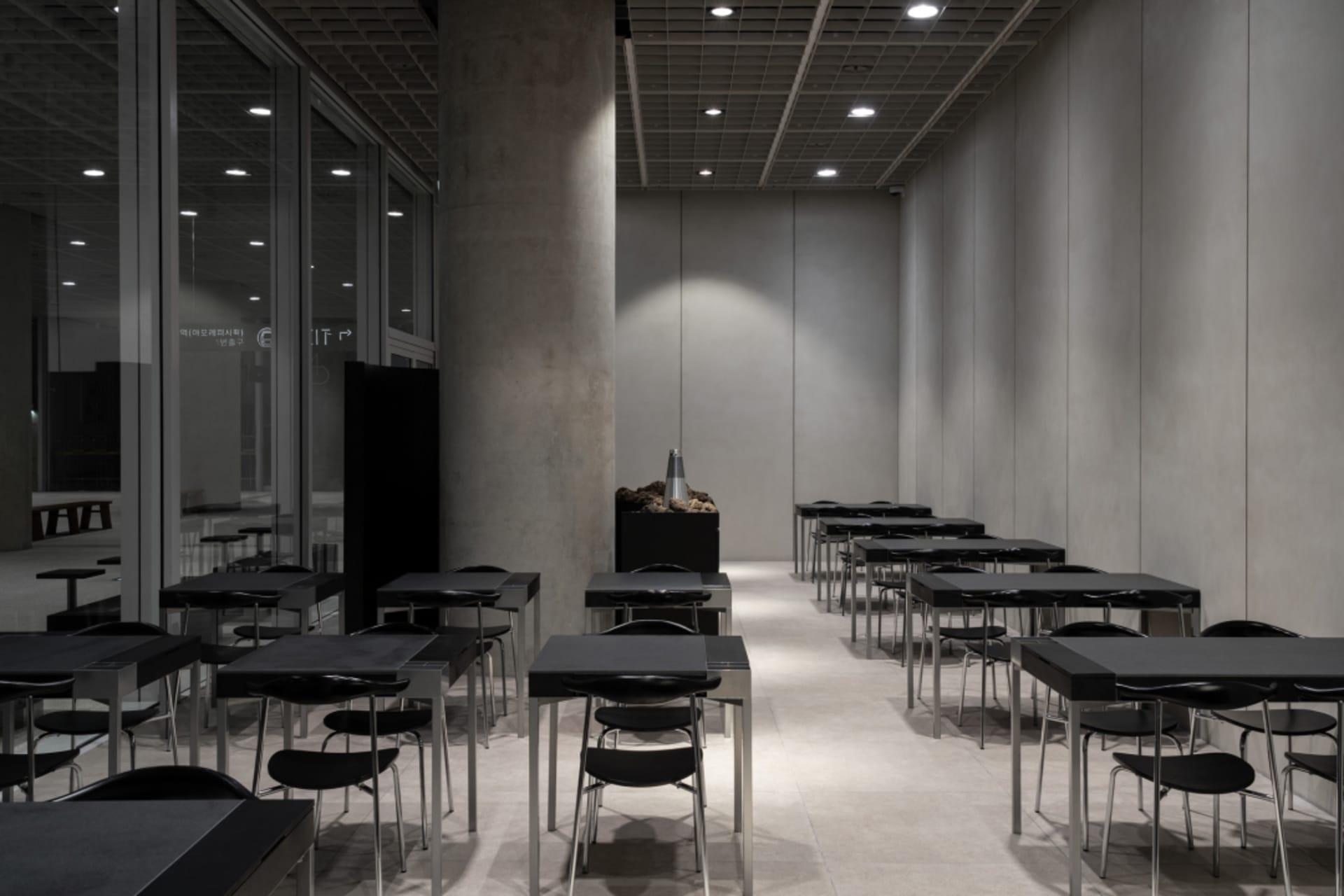 A dimly lit classroom with rows of empty desks and chairs, suggesting a space designed for educational purposes