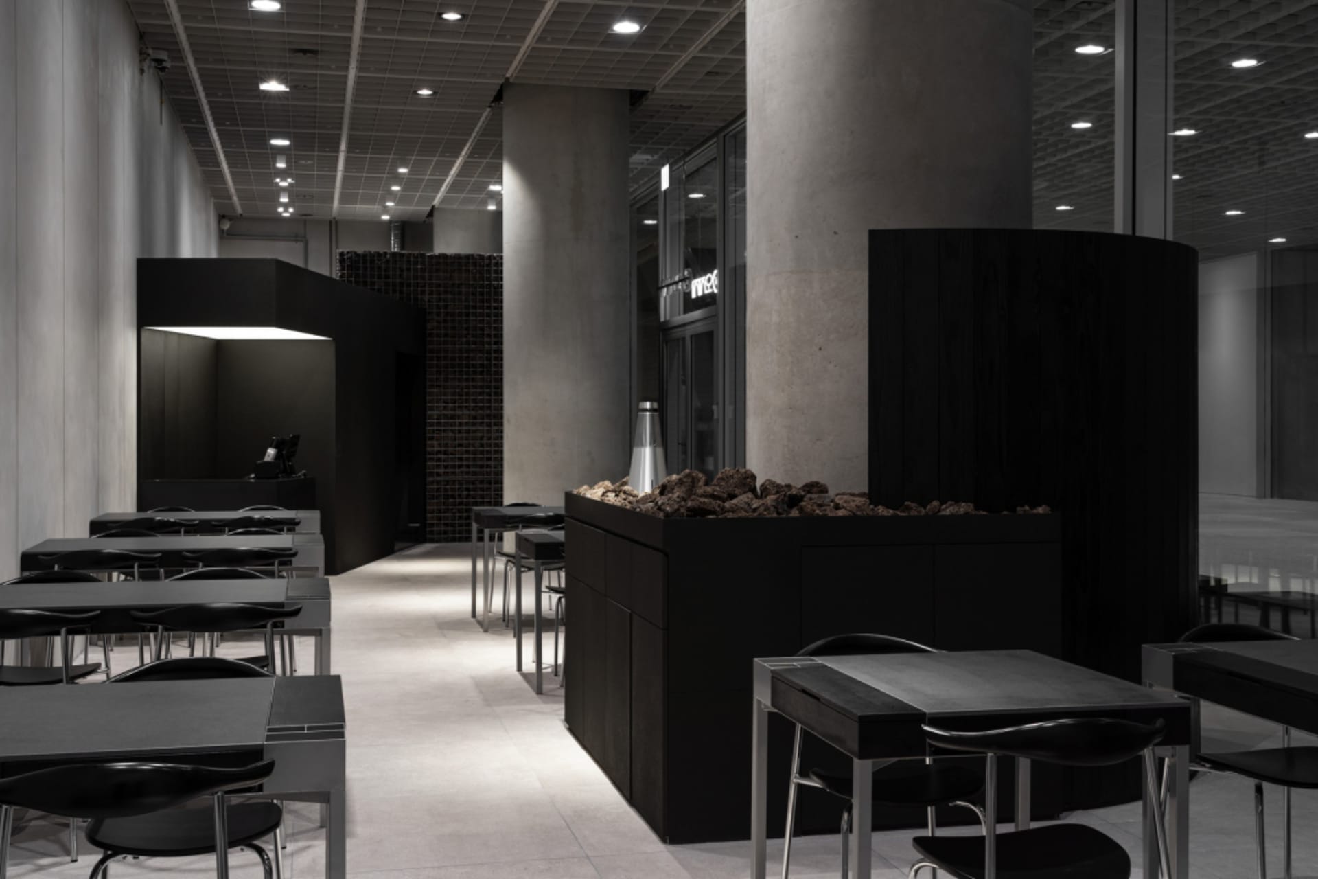 熱鬧的餐廳內部，擁有磚牆與混凝土牆面、多張餐桌與椅子，融合自然光與人工照明